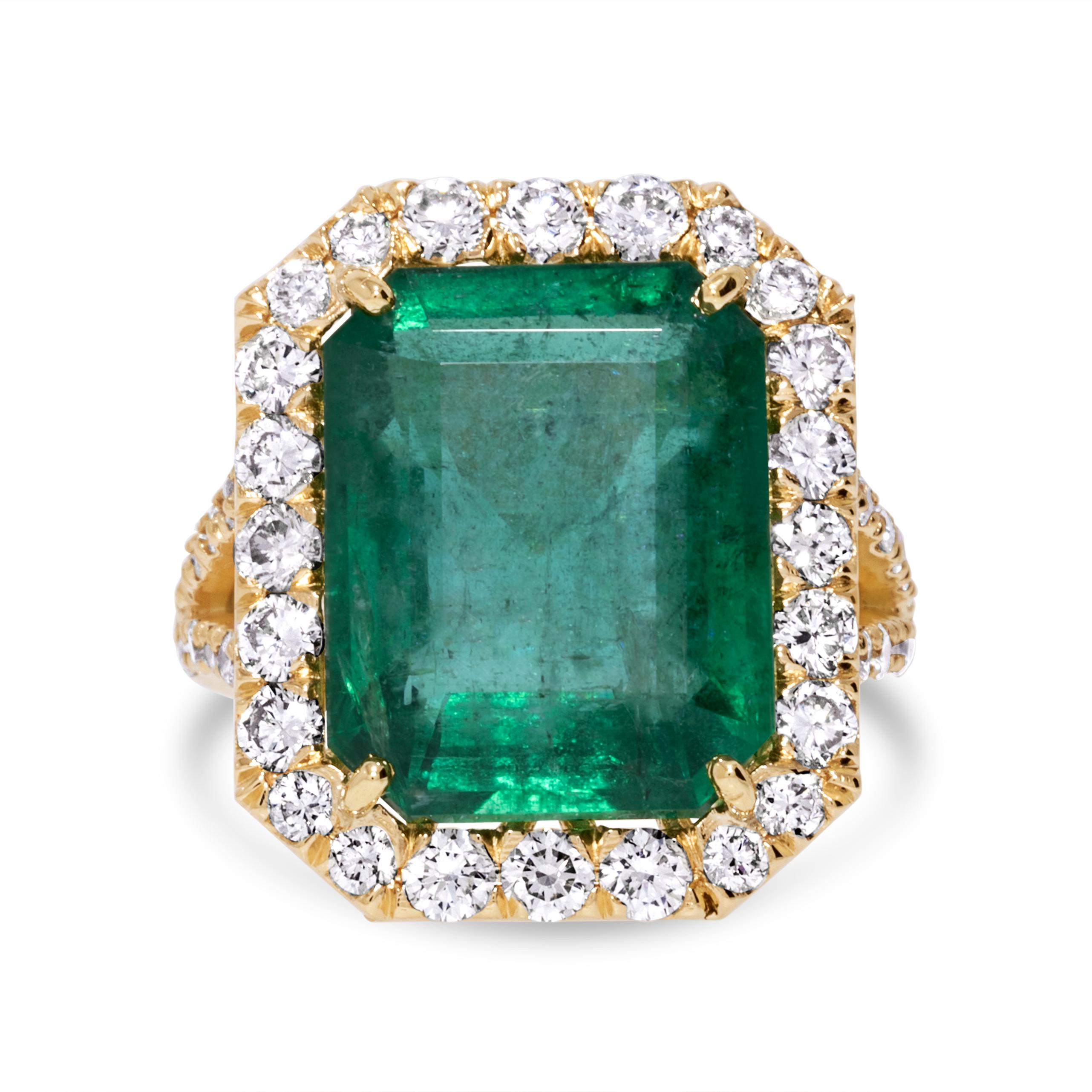 This fashion ring is crafted in 18k yellow gold and features a stunning 13.11-carat emerald. Surrounding the emerald are 52 round green diamonds, totaling 1.8 carats. The combination of the rich green emerald and sparkling green diamonds creates a