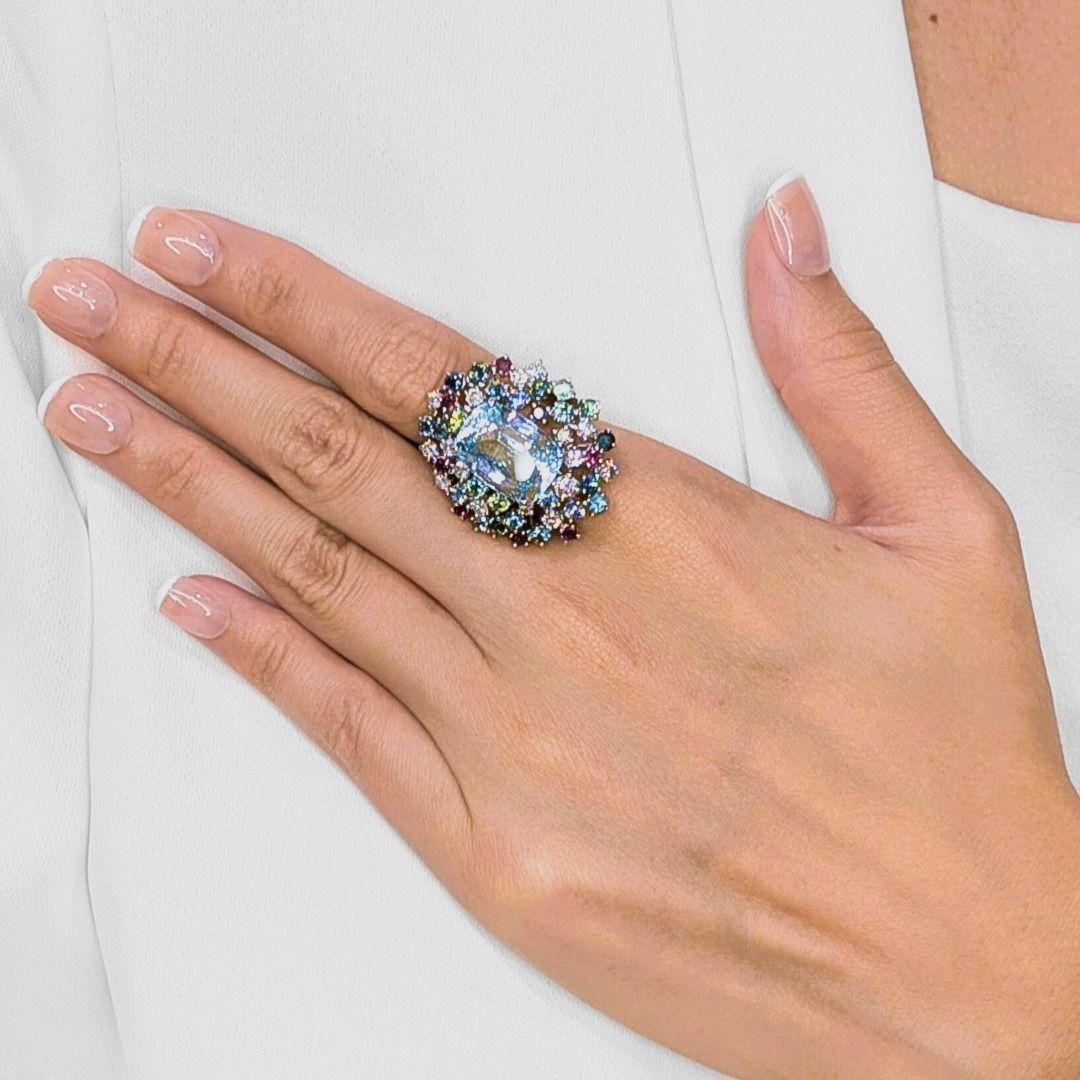 Ein wahres Statement an Kunstfertigkeit und Farbe: Dieser kühne Cocktailring präsentiert einen beeindruckenden Aquamarin im Kissenschliff von 11,74 Karat in einem ruhigen Blauton, der in der Mitte Eleganz ausstrahlt. Er ist umgeben von einem
