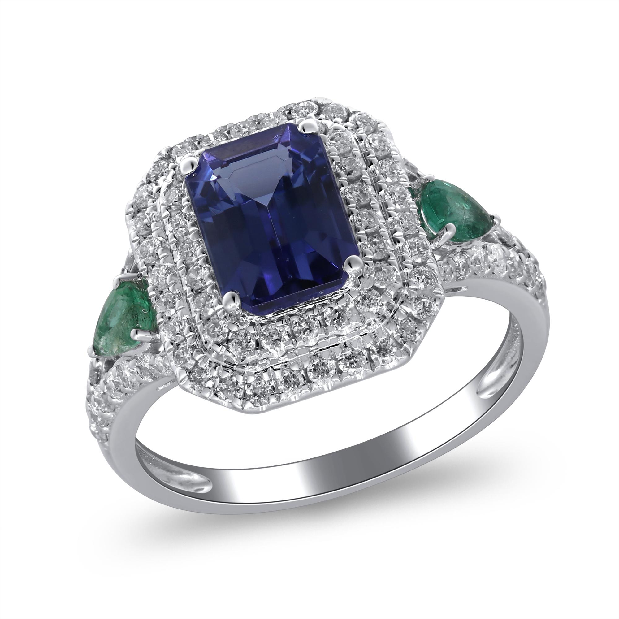 Experience the allure of this exquisite 14K white gold ring, featuring a dazzling 1.7ct emerald cut tanzanite, complemented by a sparkling halo of diamonds and emeralds. The striking blue-violet hue of the tanzanite is elegantly showcased in a