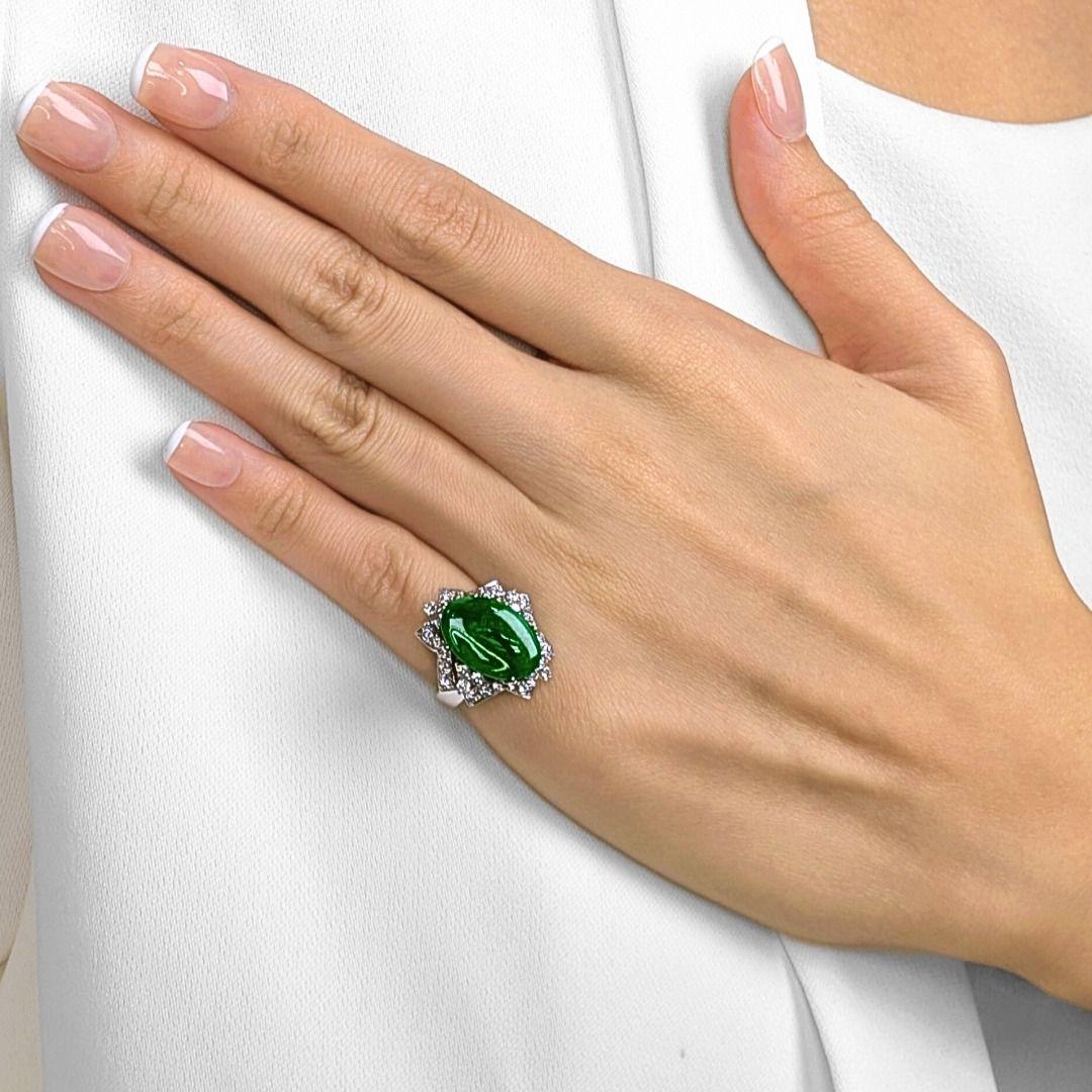 Questo grazioso anello cattura l'essenza dell'eleganza, mostrando una vivida giada verde ovale da 1ct come fulcro luminoso. Intorno alla giada, 32 diamanti tondi brillanti naturali (0,64 carati in totale, colore G, purezza VS) formano un alone