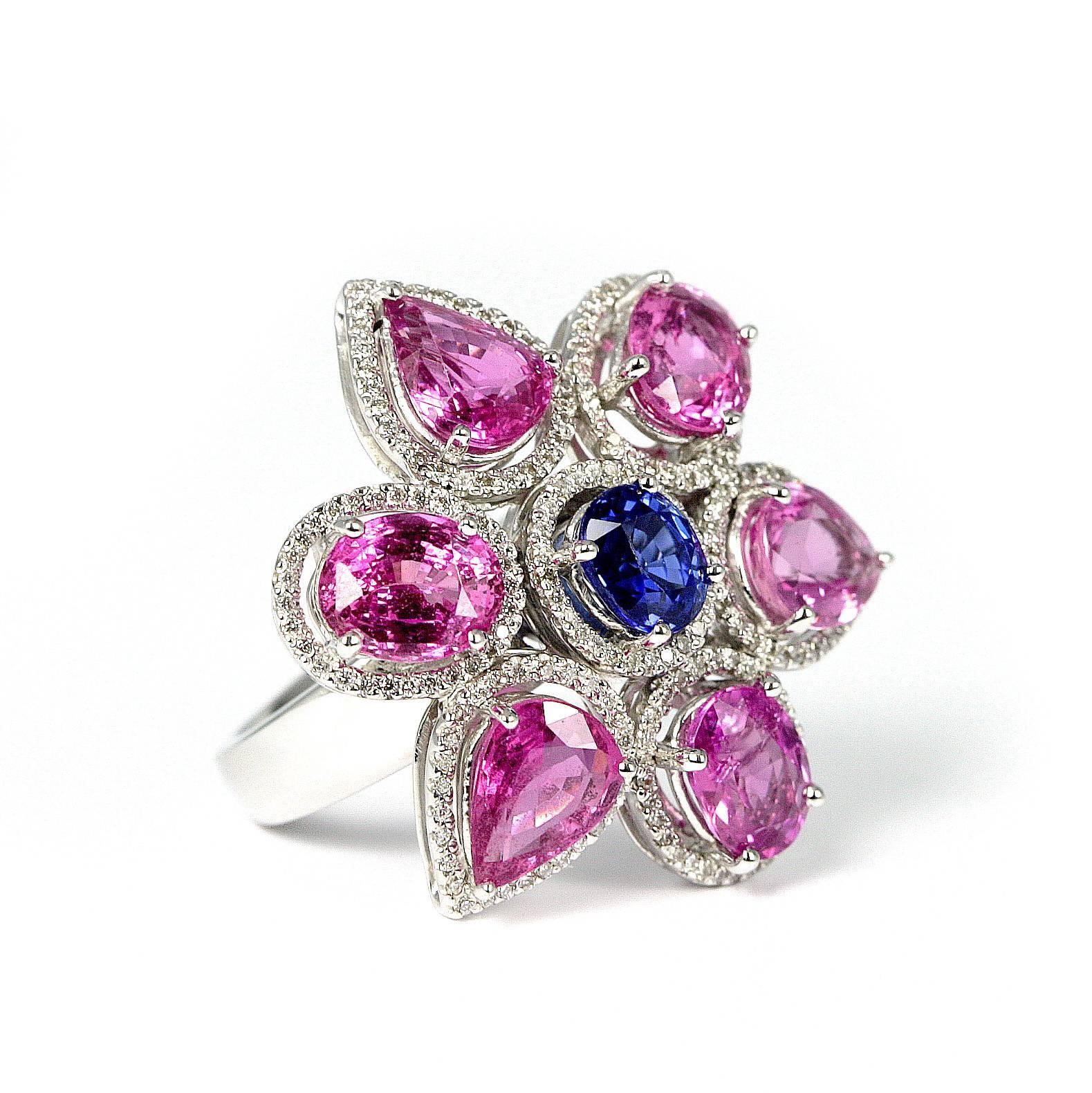 7.70 carats of beautiful pink oval and pear shape sapphires and a center blue  oval sapphire weighing approximately 1.20 carats. The 18 karat white ring is surrounded with diamonds weighing .56 carats. Size 6 1/4