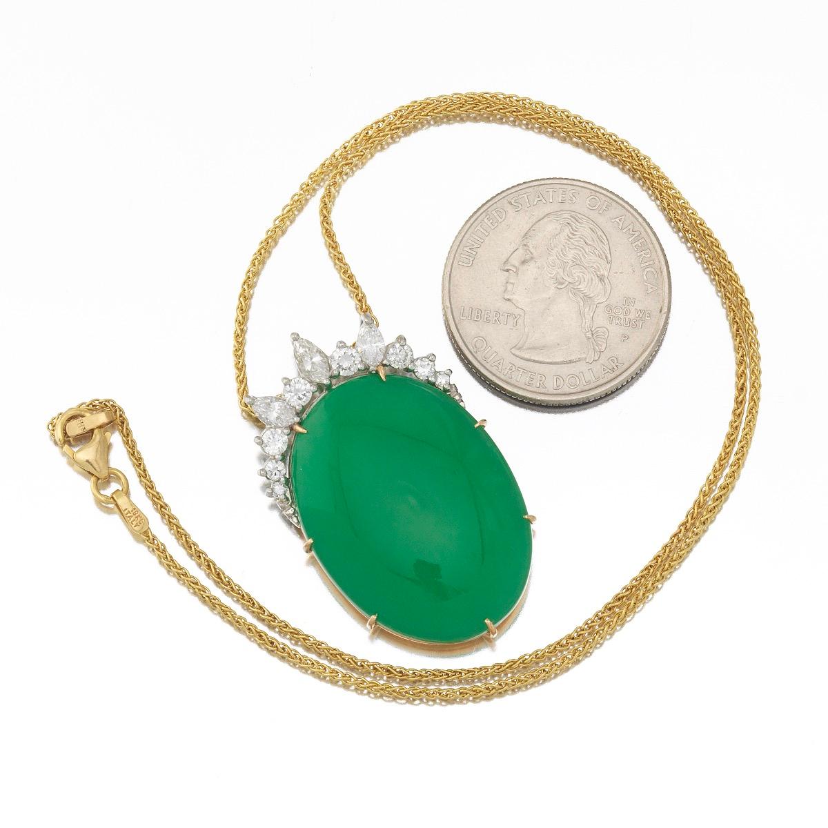 Striking platinum and 18k yellow gold pendant necklace is set with a large green chrysoprase cabochon measuring 27mm x 22mm x 6.92mm.  

The stone is surmounted by G-H VS quality round brilliant cut and marquis cut diamonds, with a total estimated