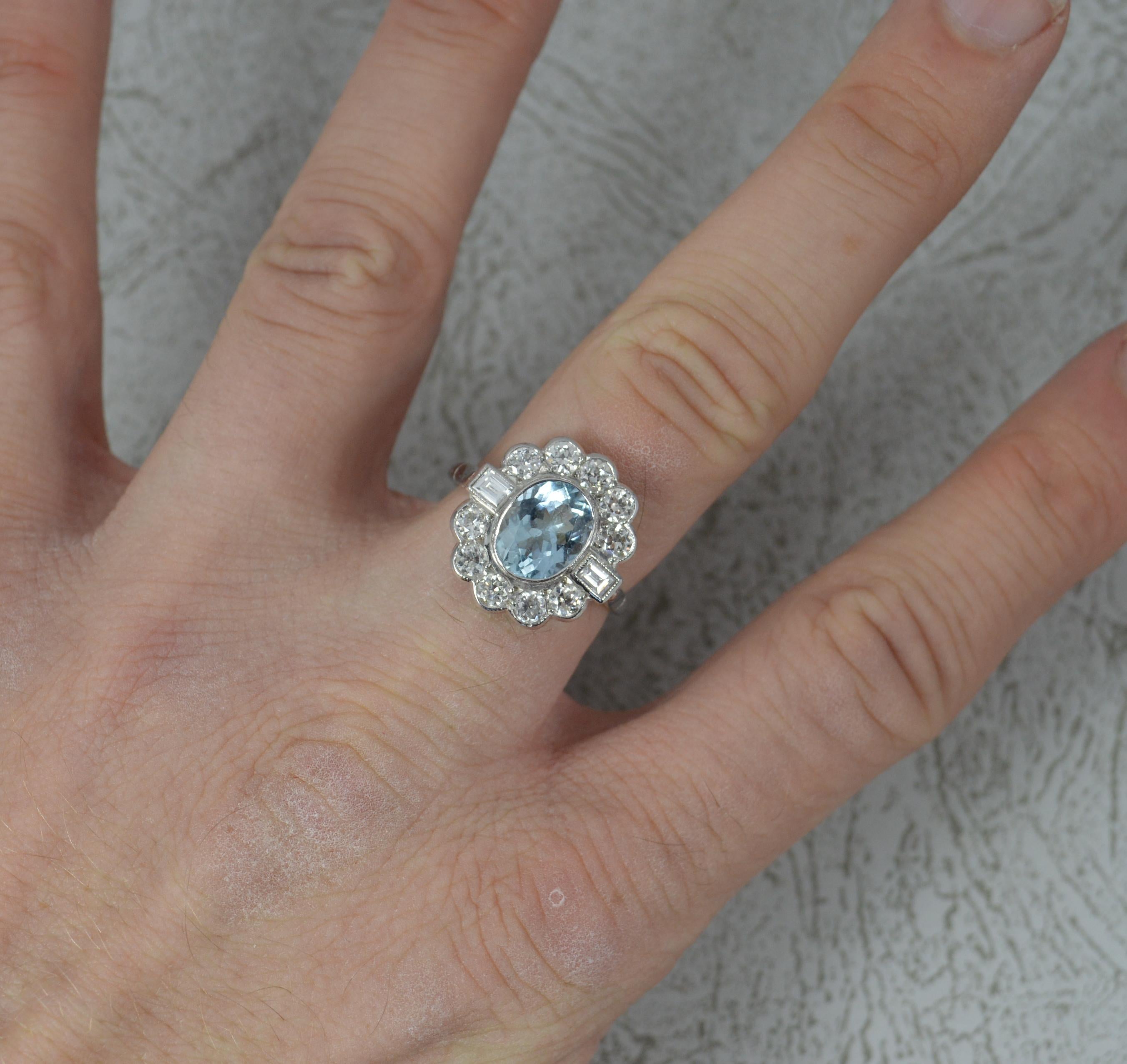 A stunning Aquamarine and Diamond cluster ring.
​Solid 18 carat white gold shank and setting.
Designed with an oval cut aquamarine to the centre in collet setting. 7.4mm x 9.2mm approx.
Surrounding are 10 natural old cut diamonds and 2 emerald cut