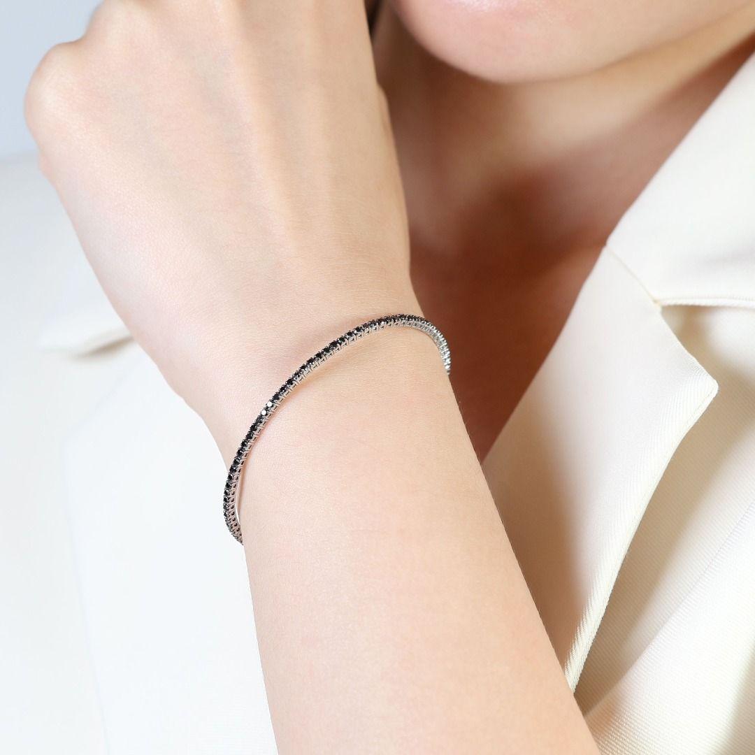 Introducing our stunning 18K White Gold Bracelet, a captivating piece designed to make a bold statement. This exquisite bracelet features a dazzling array of seventy-four round brilliant black stones, each carefully selected for its rich hue and