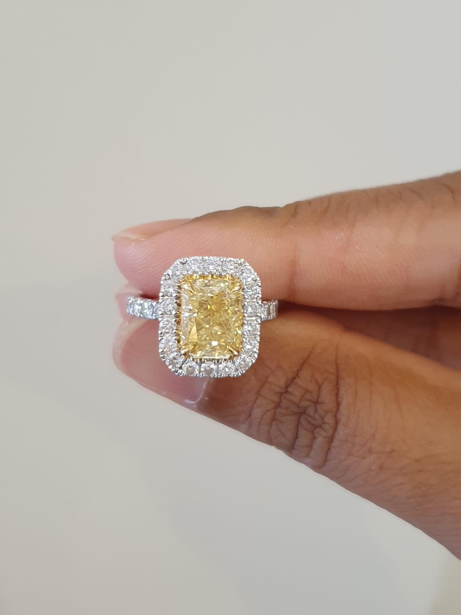 Stunning halo ring made from 18k white gold with 3.702 total carats of fancy radiant diamond and round brilliant diamonds. This ring comes with a fancy box.

-1 diamond main stone of 2.56 ct. 
cut: radiant
color: fancy intense yellow
clarity: