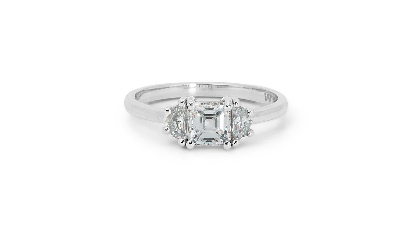 A marvelous three-stone ring with a dazzling 0.9 carat square emerald cut natural diamond. It has 0.25 carat of side diamonds which add more to its elegance. The jewelry is made of 18k white gold with a high-quality polish. It comes with GIA