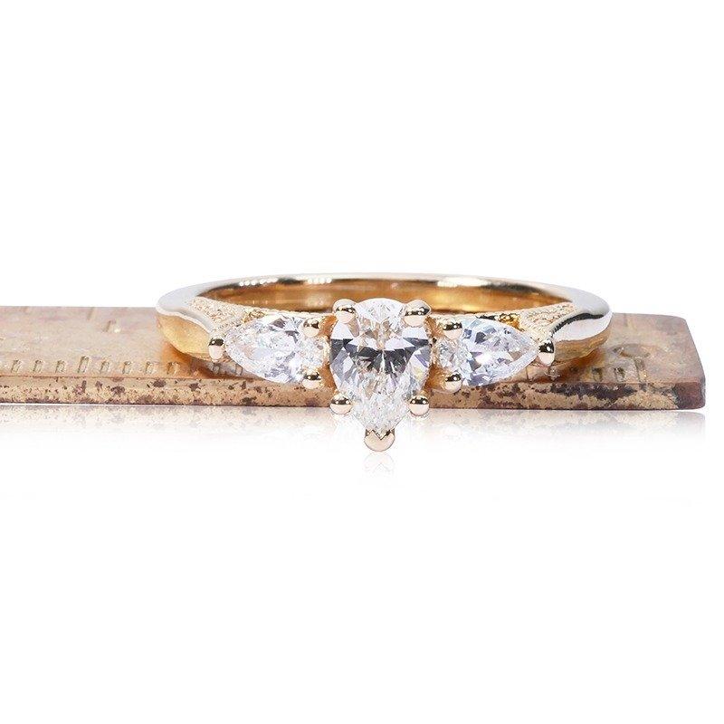 Stunning 3 stone ring made from 18k yellow gold with 0.75 total carat of pear shape diamonds. This ring comes with an AIG report and a fancy box.


-1 diamond main stone of 0.44 ct.
Cut: Pear
Color: F
Clarity: VS2
Cut grade: VG

-2 diamond side