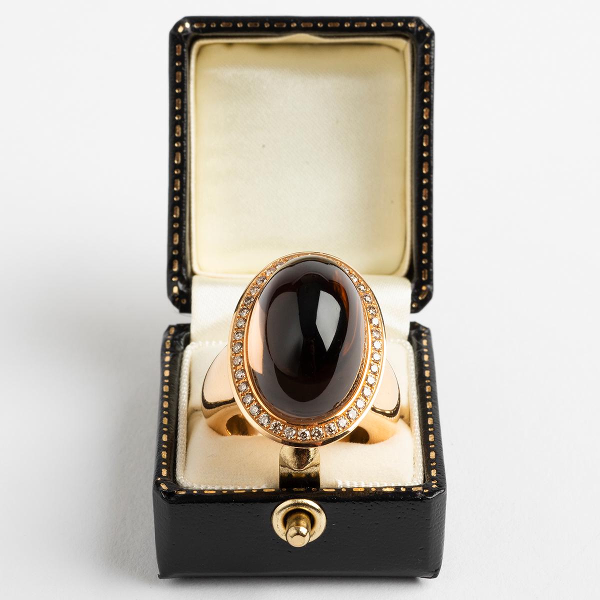 Our rare and large 18k yellow gold dress ring features a phenomenal and noteworthy smokey quartz of considerable dimension, as well as a diamond clad setting. This ring size is O1/2. A unique statement piece for the discerning collector.