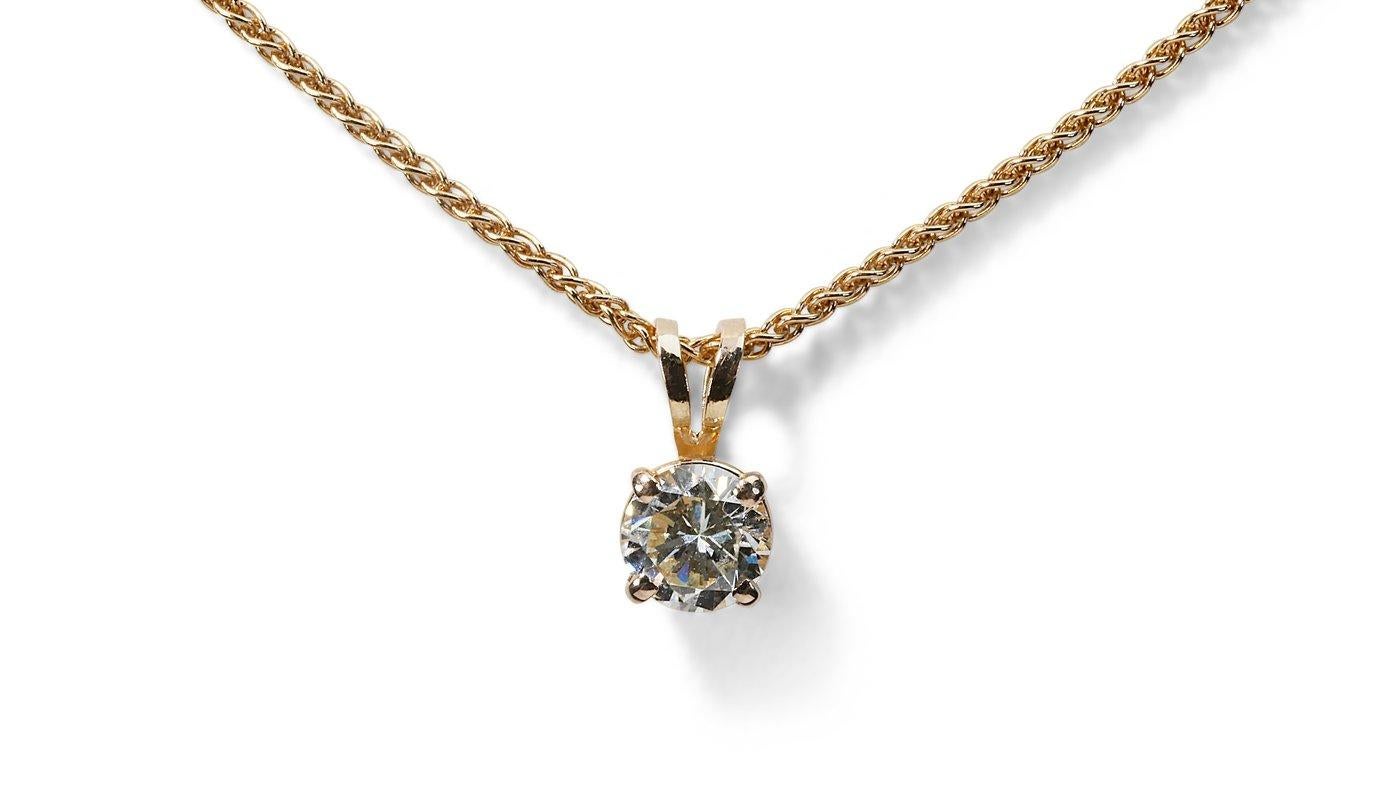Magnifique collier solitaire orné d'un éblouissant diamant naturel rond de 0,9 carat de couleur H IF. Le bijou est en or jaune 18 carats avec un polissage de haute qualité. La pierre principale est gravée d'une inscription au laser et est