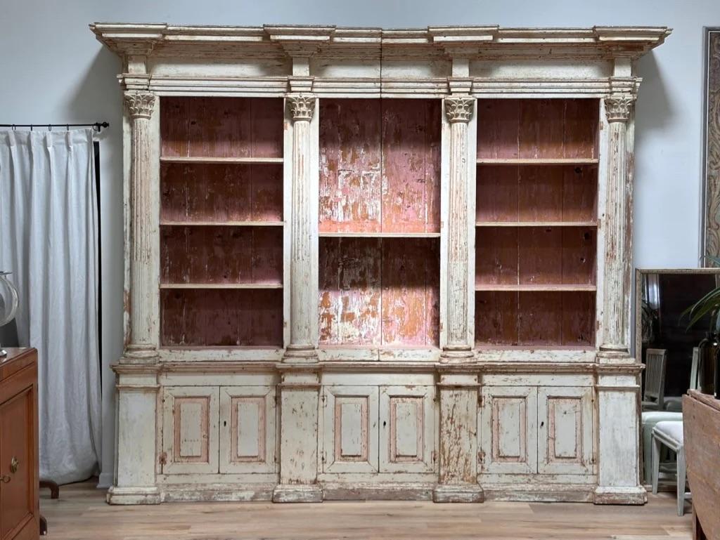 Dating from the 18th Century and of Italian origin, this fine grand scale bookcase has a molded frieze above a three-bay open bookcase. Each bay contains shelves flanked by Corinthian columns surmounted by block capitals and molded tapered