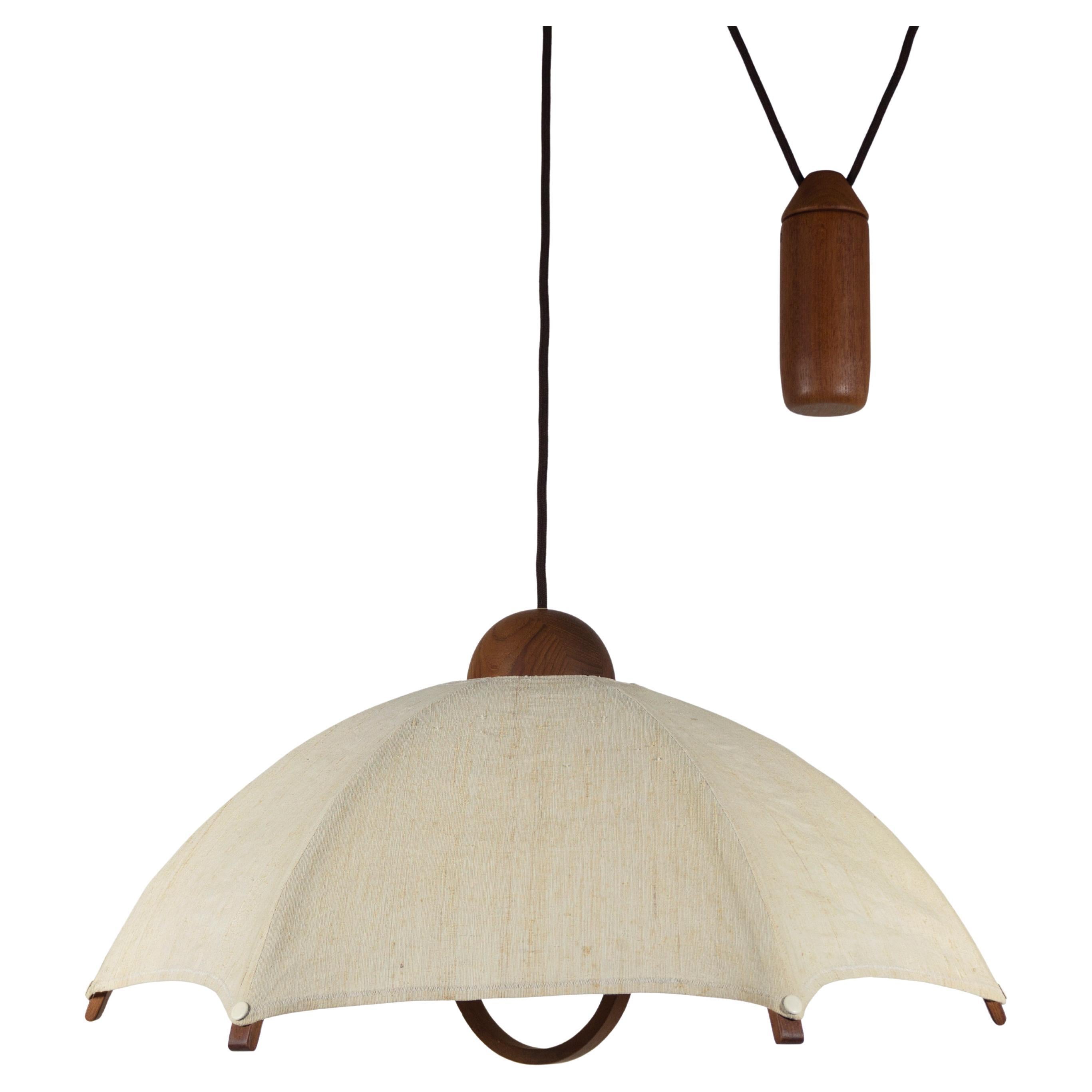 Stunning and large vintage teak pendant lamp with counterweight from Domus, type 2407.
The height-adjustable lamp is made of solid teak wood. The lamp also has a practical teak handle with which the height can be easily adjusted. Equally practical