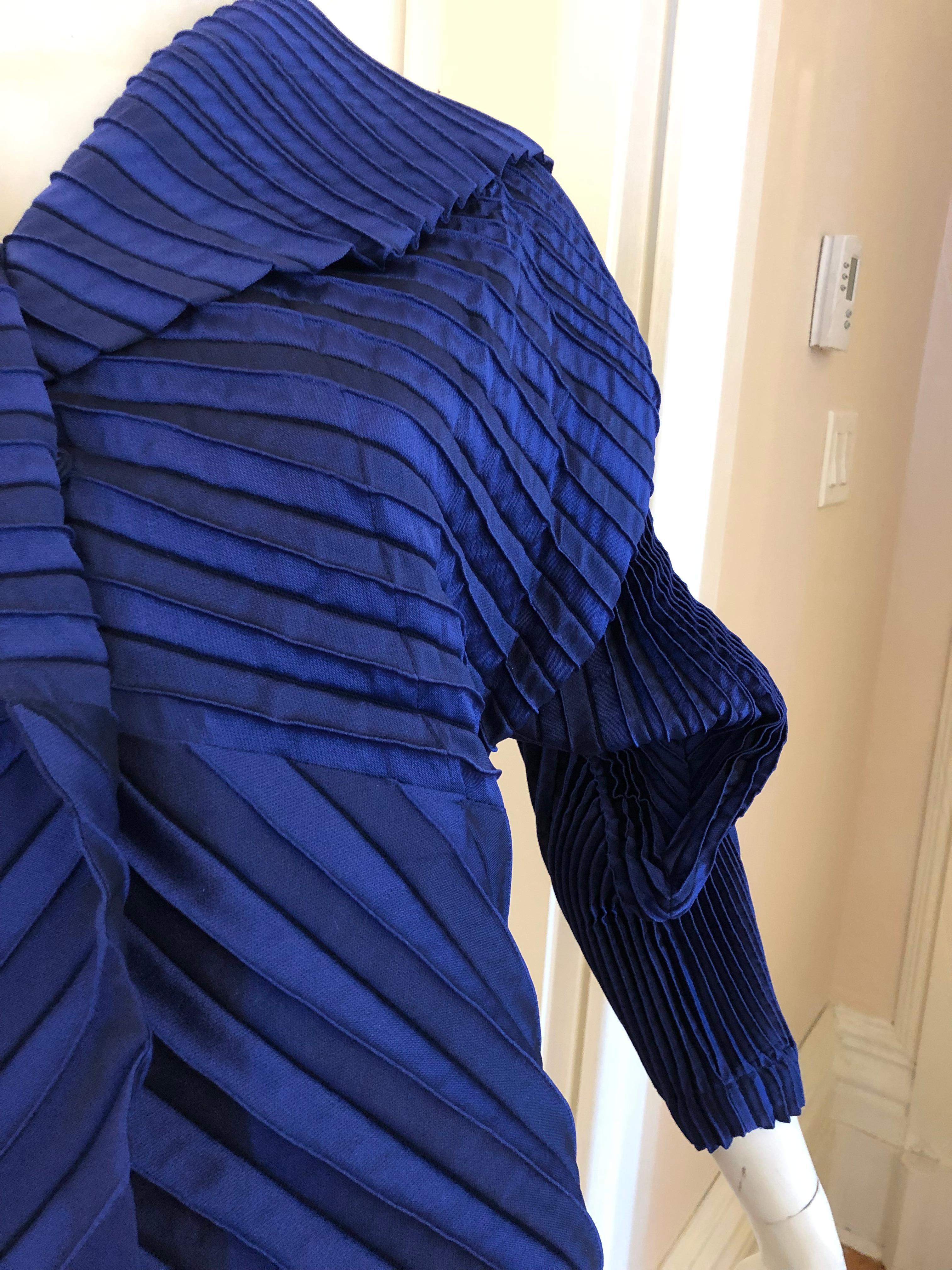 Typical of Issey Miyake's avant guarde architectural style, this jacket has permanent pleating and a wonderful chevron pattern. The sleeves are twisted and three dimensional, and the shawl collar is supplemented with a one button and three snap