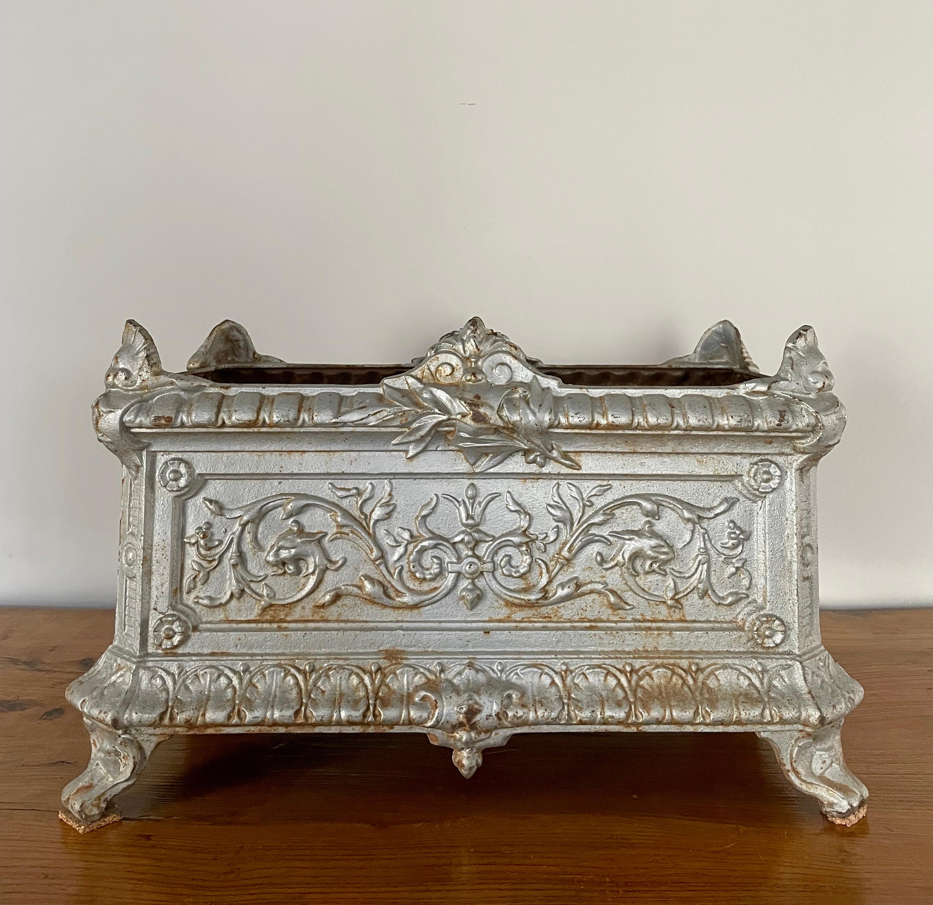 This is a fabulous French 19th Century jardinière in its original silver paint, but sadly, it is lacking part of one foot (an inelegant solution is a piece of cork, but we think a new foot could be fashioned from Bondo). It perfectly embodies the