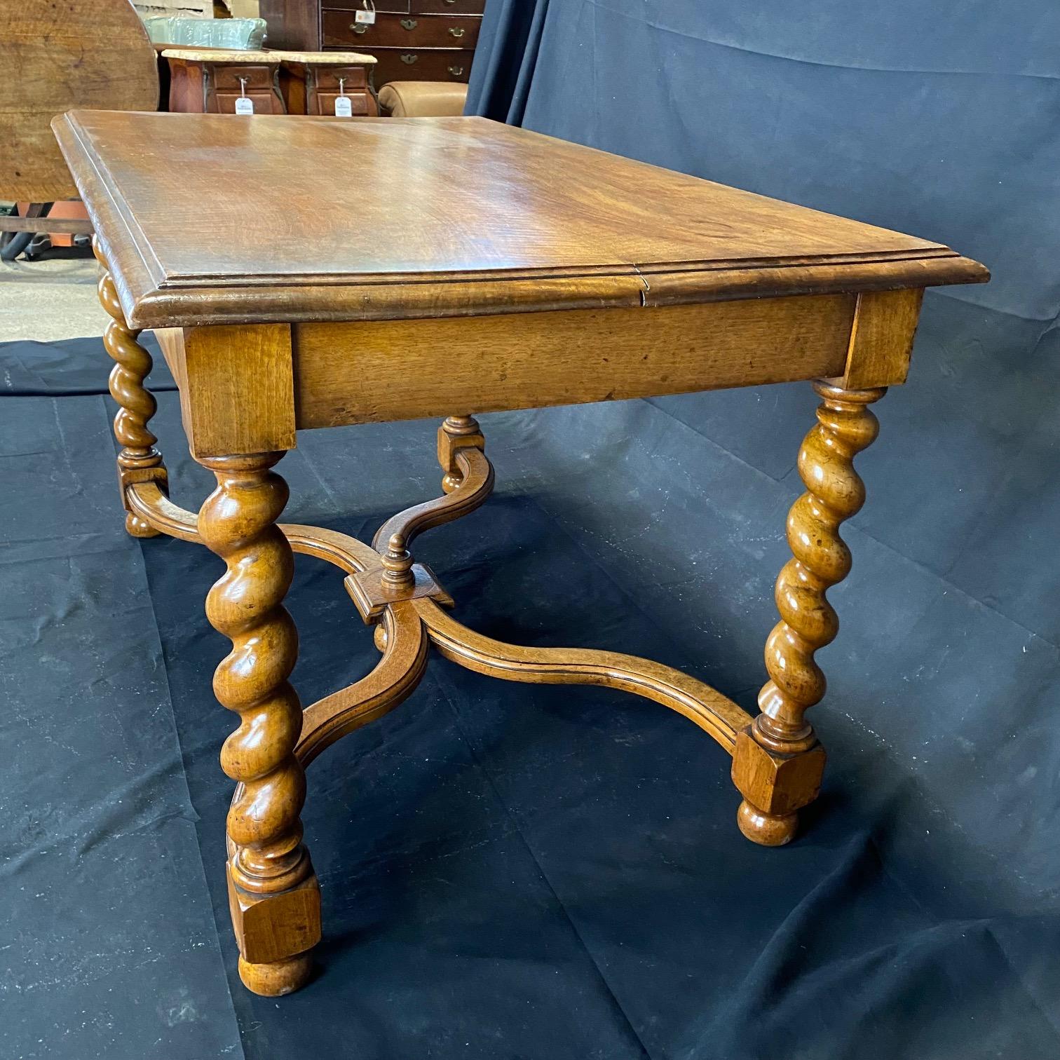 Elegant walnut French table having barley twist design with a capped pediment crowning the stretchers. Very versatile as far as uses, such as a dining table, desk or rectangular center table. The bottom stretchers are 4.5 H and have a marvelous