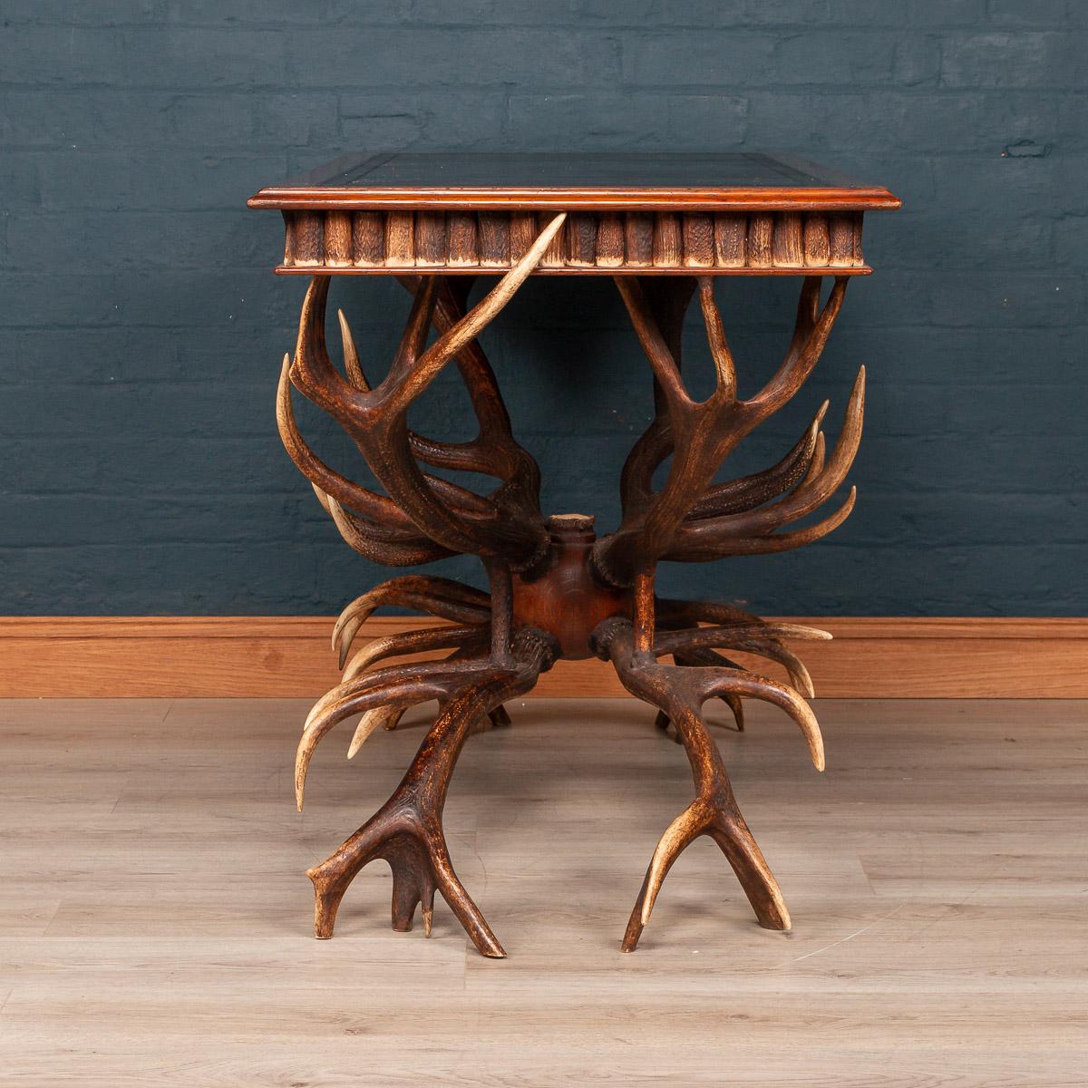 An extremely unusual mid-20th century library table by Anthony Redmile. The side of the table profusely decorated with sections of antler Horn and the table leg fashioned from whole antlers. The British designer Anthony Redmile was known in the