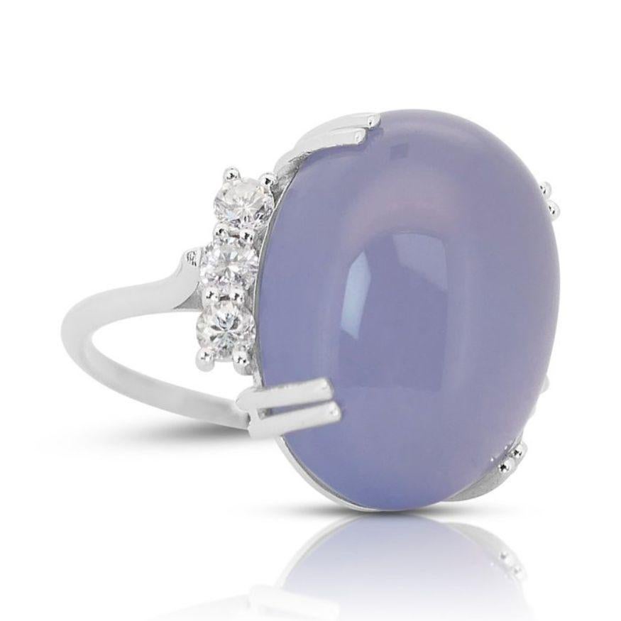 This stunning ring features a magnificent oval cabochon-cut quartz as its centerpiece, boasting an impressive weight of 21.55 carats. The quartz exhibits a captivating violetish blue hue, adding a touch of enchantment and sophistication to any look.