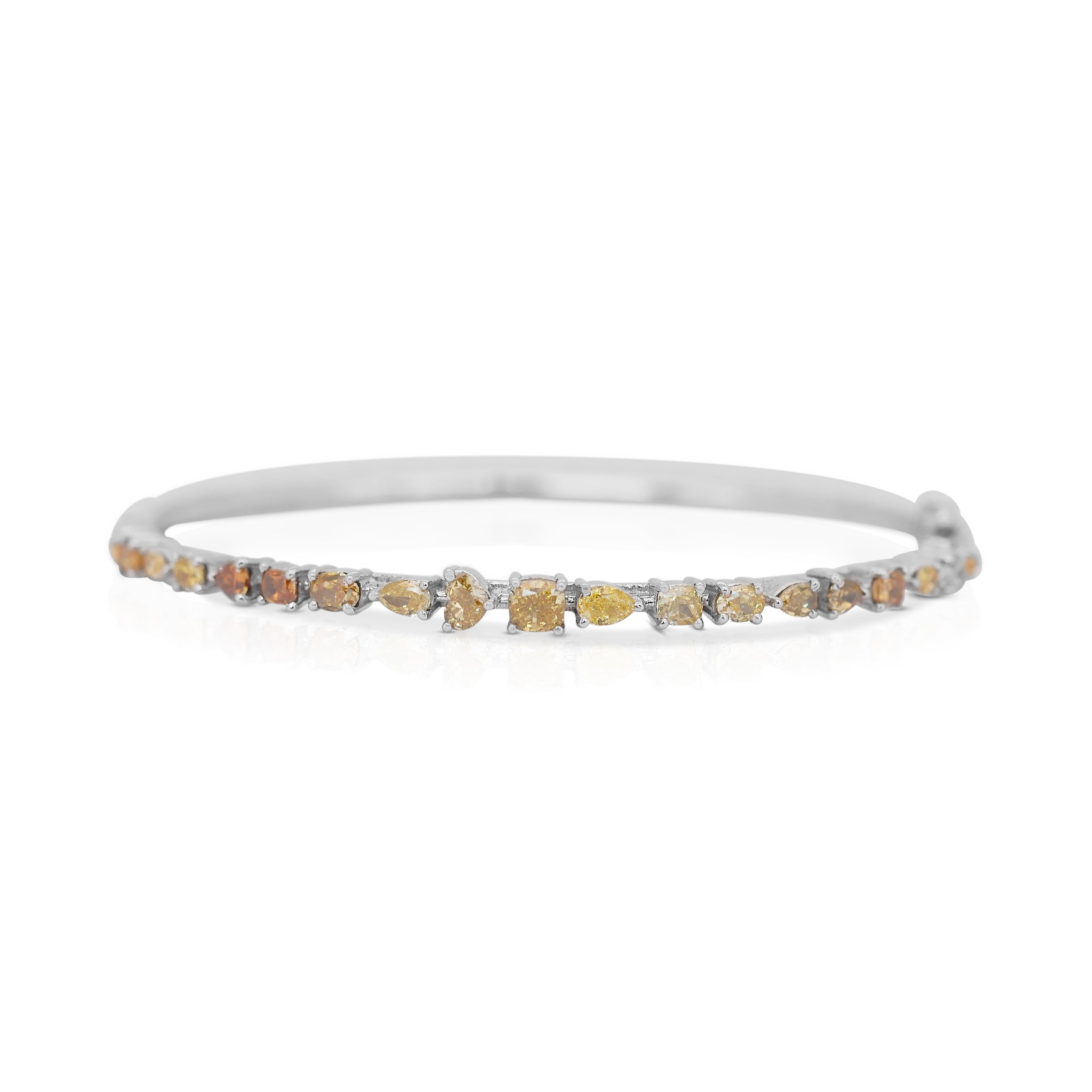This stunning fancy-colored bracelet is adorned with 19 dazzling diamonds in unique fancy shapes, totaling 3.38 carats. The diamonds display a captivating array of vivid hues, these vibrant diamonds shine brightly, creating a truly eye-catching