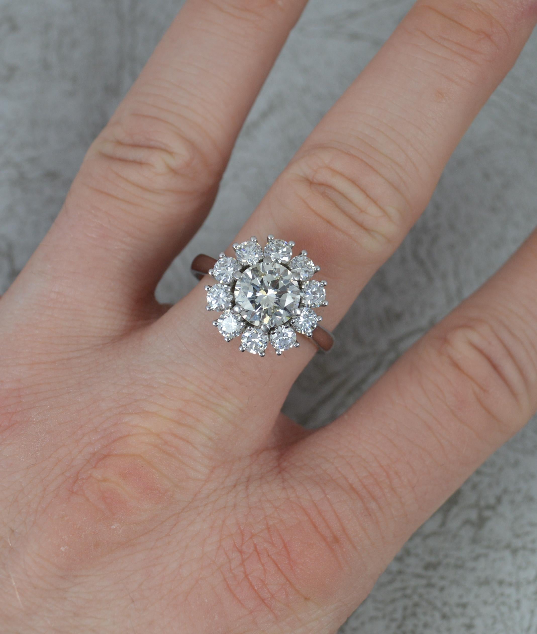 A stunning diamond cluster ring.
Solid and heavy 18 carat white gold example.
Designed with a natural round brilliant cut diamond to the centre, 8.00mm diameter, 2.00 carats. Surrounding are ten further round brilliant cut diamonds, each 0.15