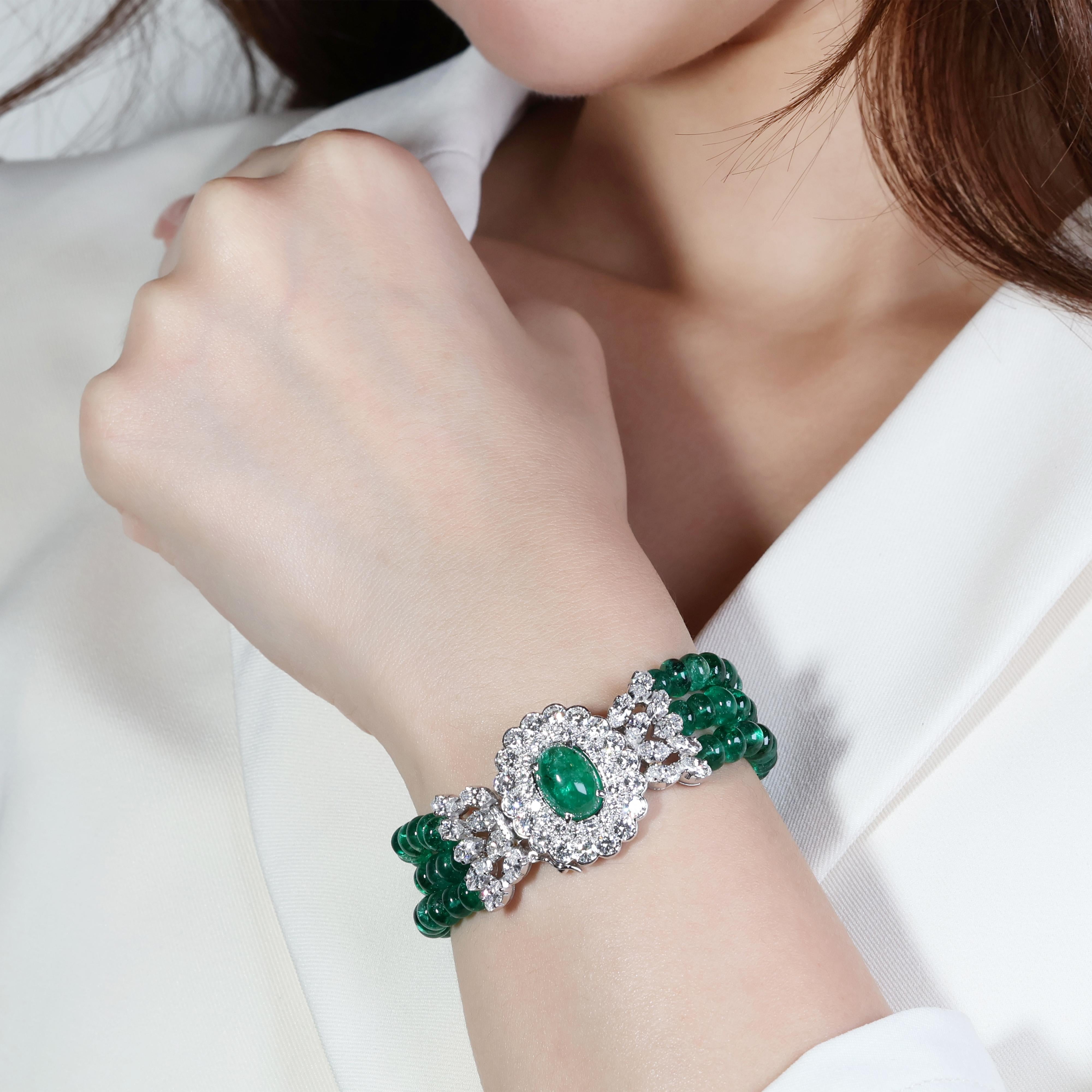 Dieses exquisite Armband besticht durch seine Smaragde, Berylle und Diamanten, die sorgfältig in luxuriöses 18-Karat-Weißgold gefasst sind. Das Herzstück ist ein faszinierender Cabochon-Smaragd mit bemerkenswerten 4,76 Karat und einer intensiven