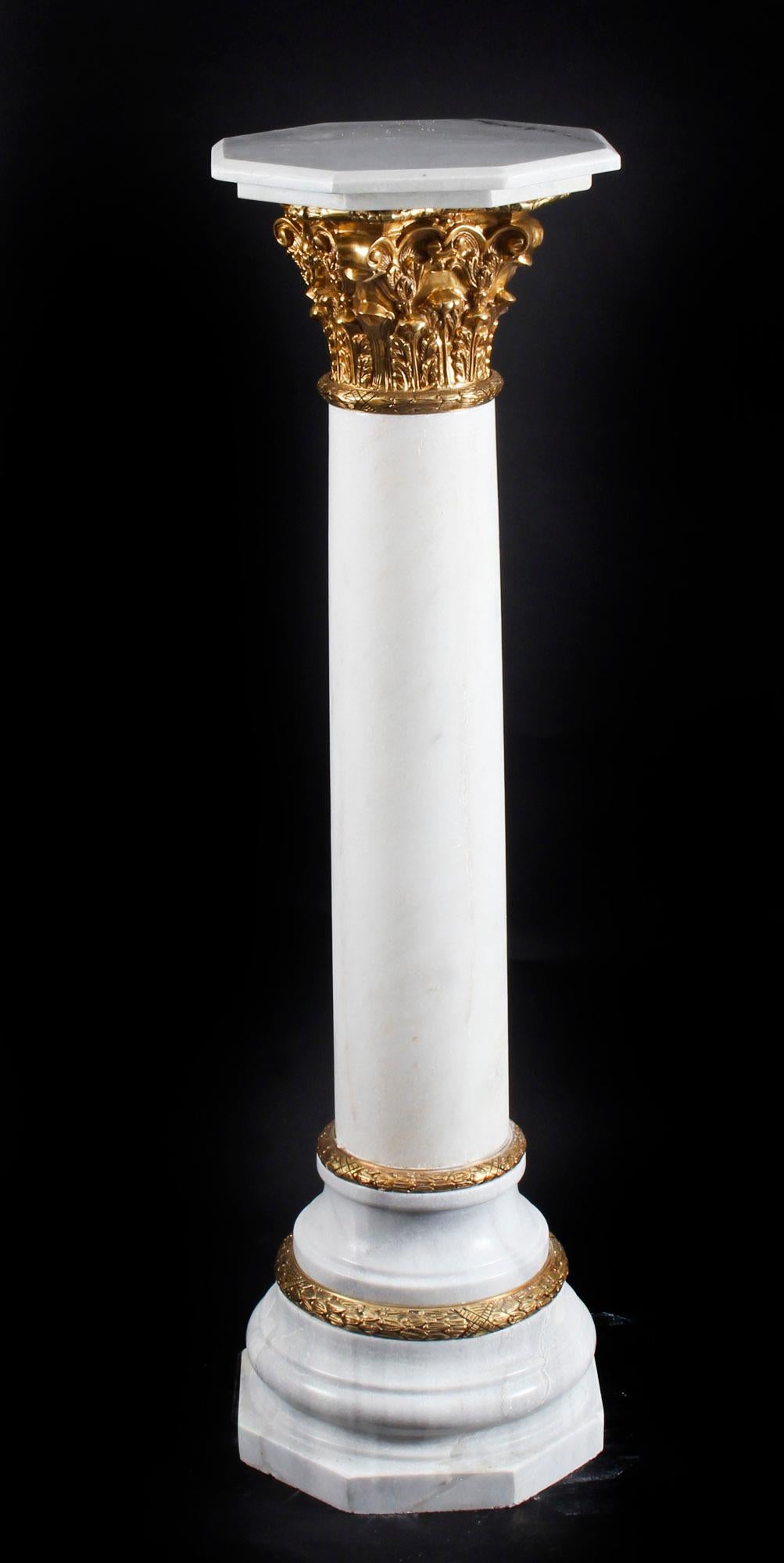 This is a gorgeous white marble Corinthian Column pedestal with gilded bronze 'ormolu' mounts, in classical Empire style. 

The pedestal is perfect for displaying bronzes, marble statues or porcelain vases and is sure to become the centrepiece of