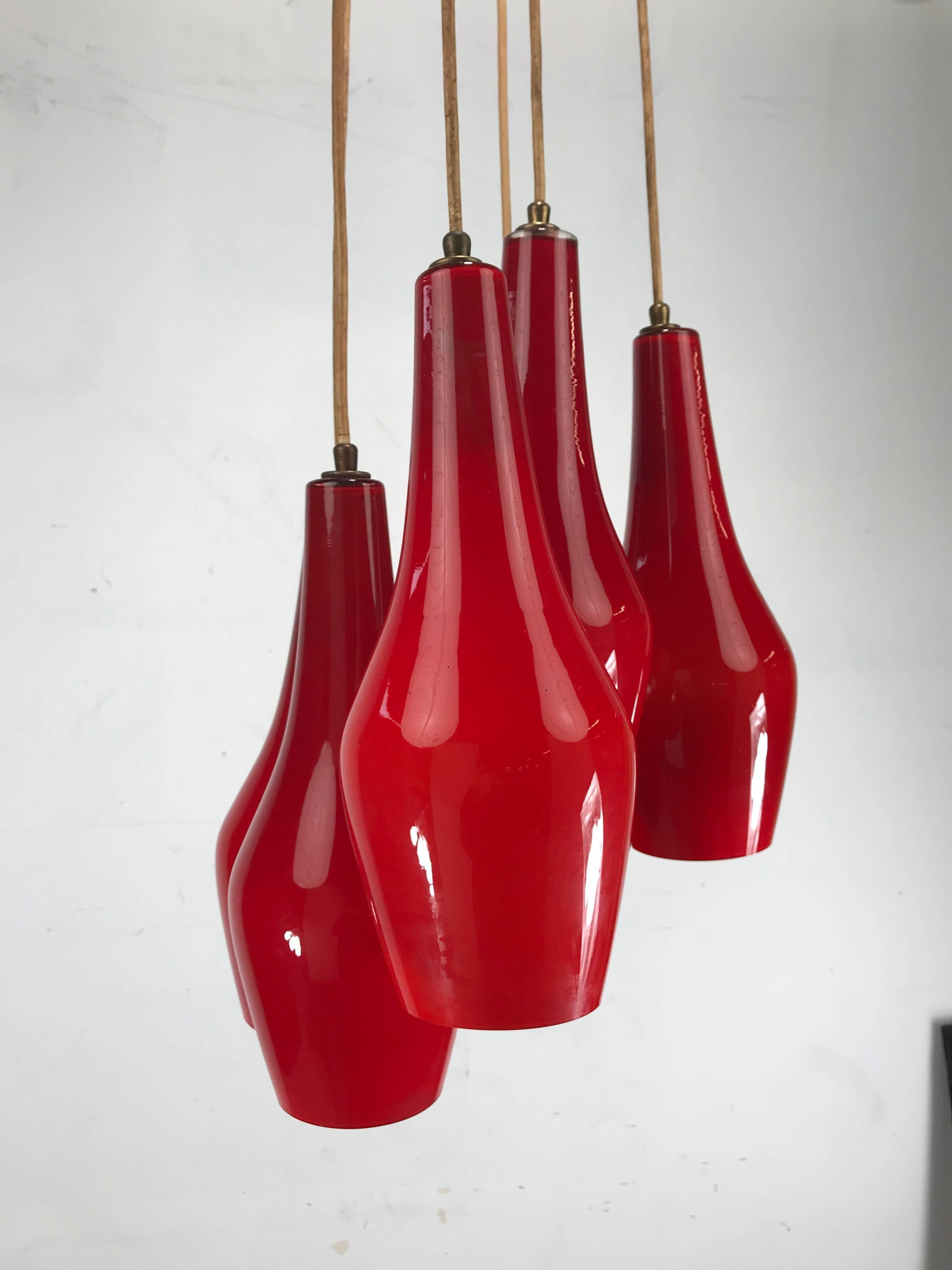 Six matching Vistosi attributed pendant cluster chandelier, circa 1962, Classic Mid-Century Modern form. Stunning Chinese red with white encased glass interior .Retains original wiring, cords and canopy, total diameter 32