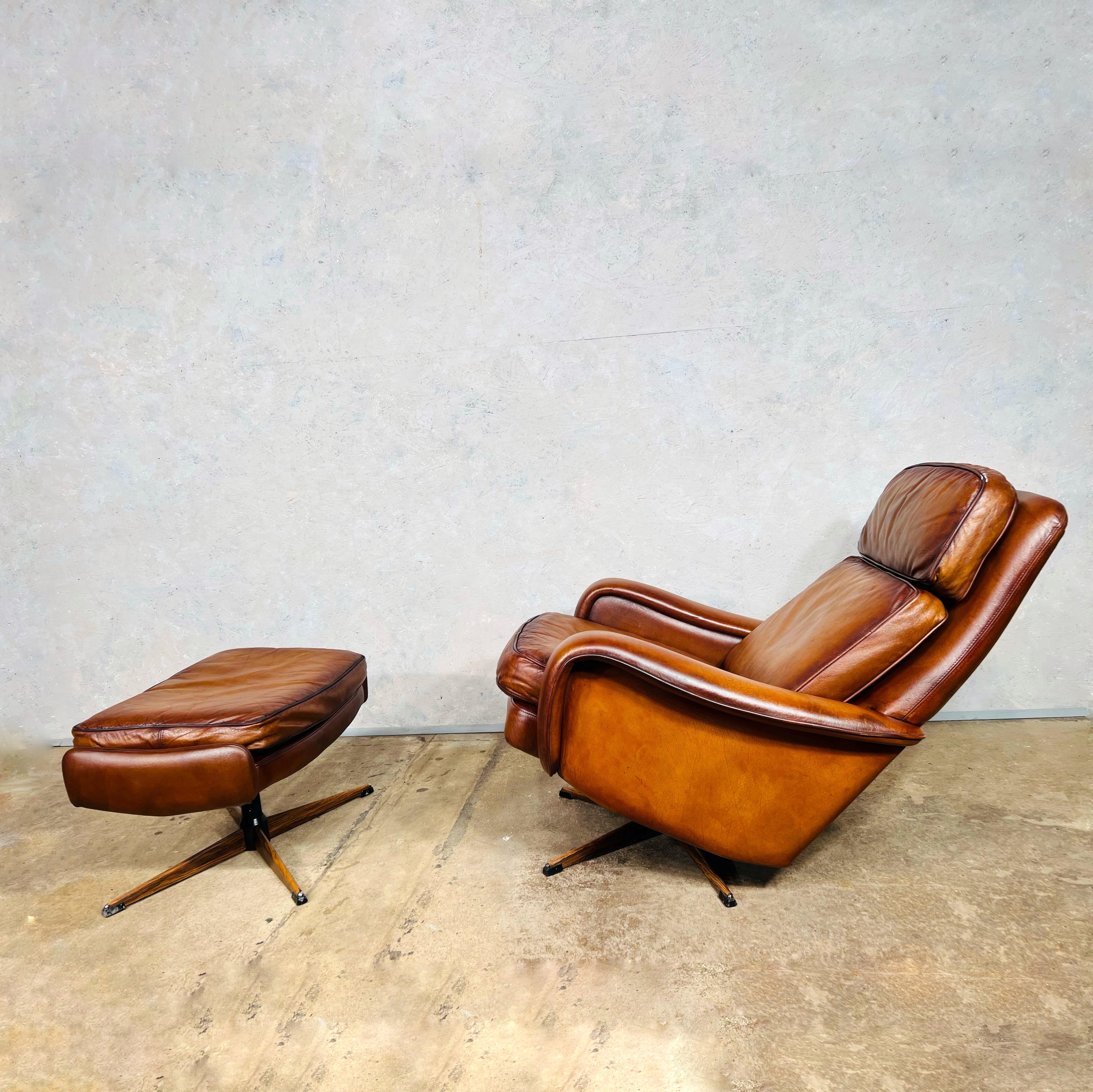 Superbe chaise pivotante et tabouret en cuir à dossier basculant de style Vintage By des années 1970. Cuir grainé de haute qualité avec une fantastique couleur Tan.
Belle patine et finition. Le fauteuil est doté d'un mécanisme de basculement du