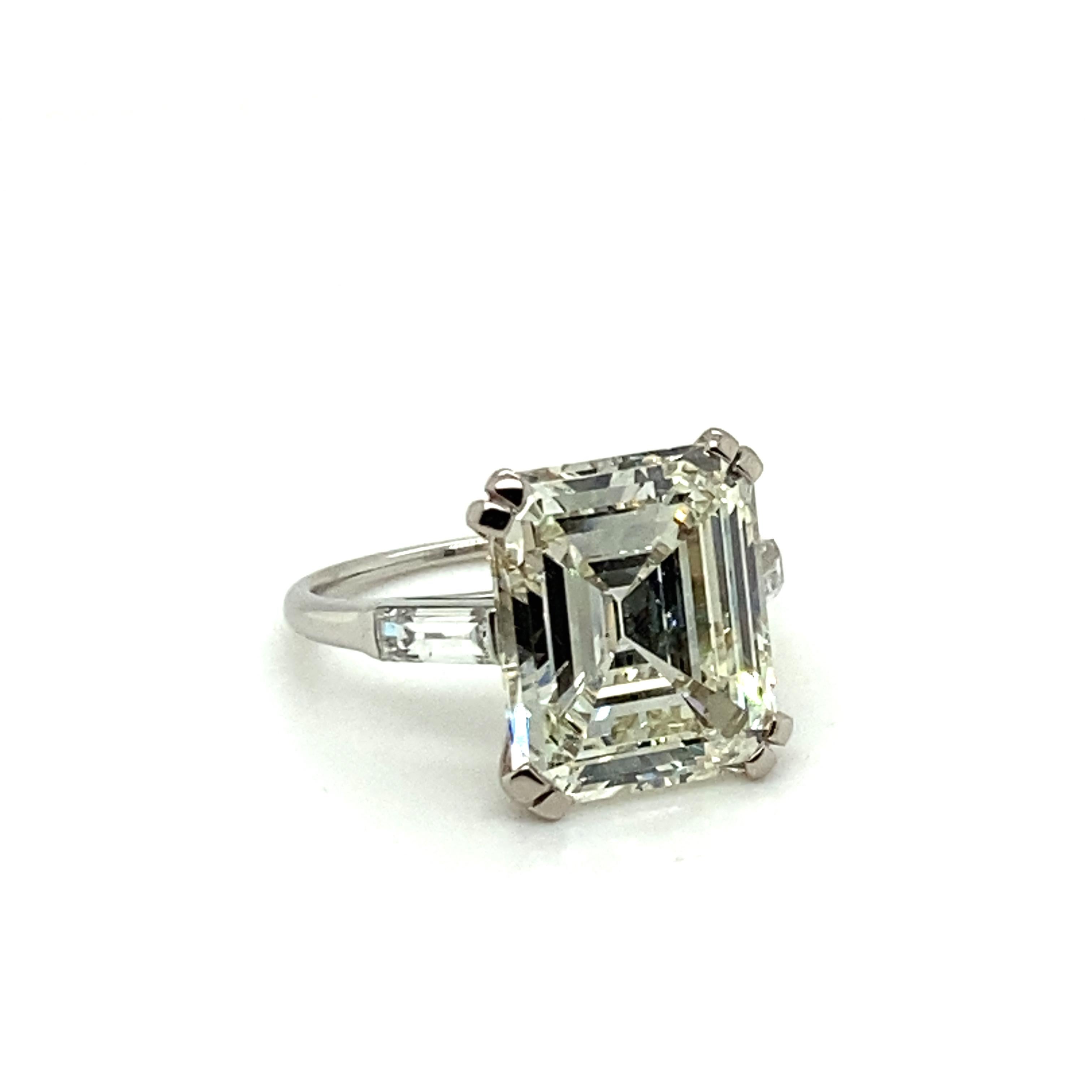 This fabulous diamond ring in platinum 950 dazzles with a 7.34 ct emerald-cut diamond of K colour and vs2 clarity. Elegantly and timelessly set in four double prongs and accented with two diamond baguettes with a total weight of approximately 0.40