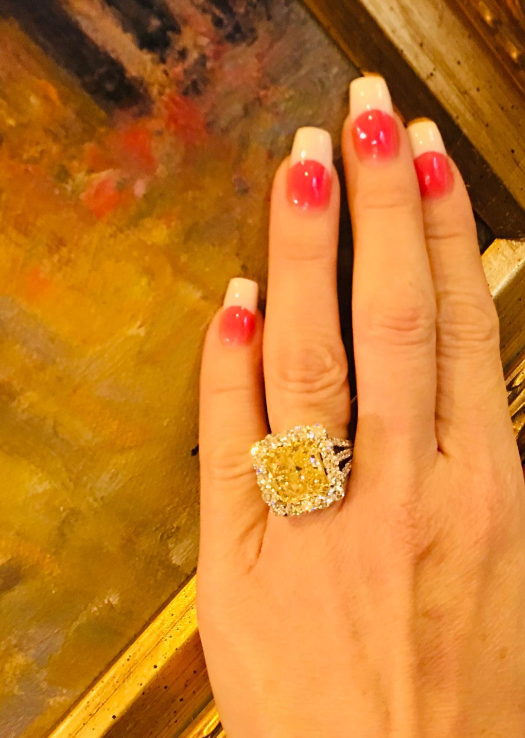 Magnificent custom estate ring features an EGL-USA Certified, 8.48 carat, cut corner square, modified brilliant cut, fancy yellow diamond. Fancy yellow diamond is mounted in a custom halo style 18 karat white and yellow gold mounting with 5.29