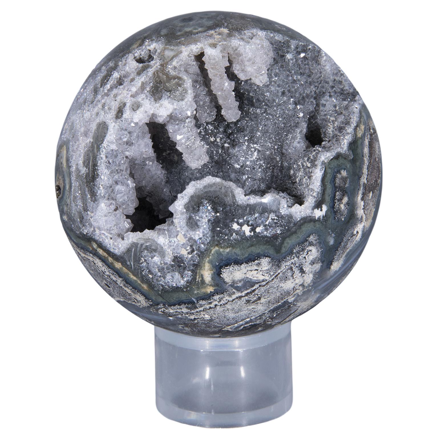 An exquisite agate geode sphere in sea green color with unusual stalactite formation and grey amethyst druse. 

This stunning piece is a real evocation of the natural beauty of minerals. The piece is completely polished and reveals a mix of green