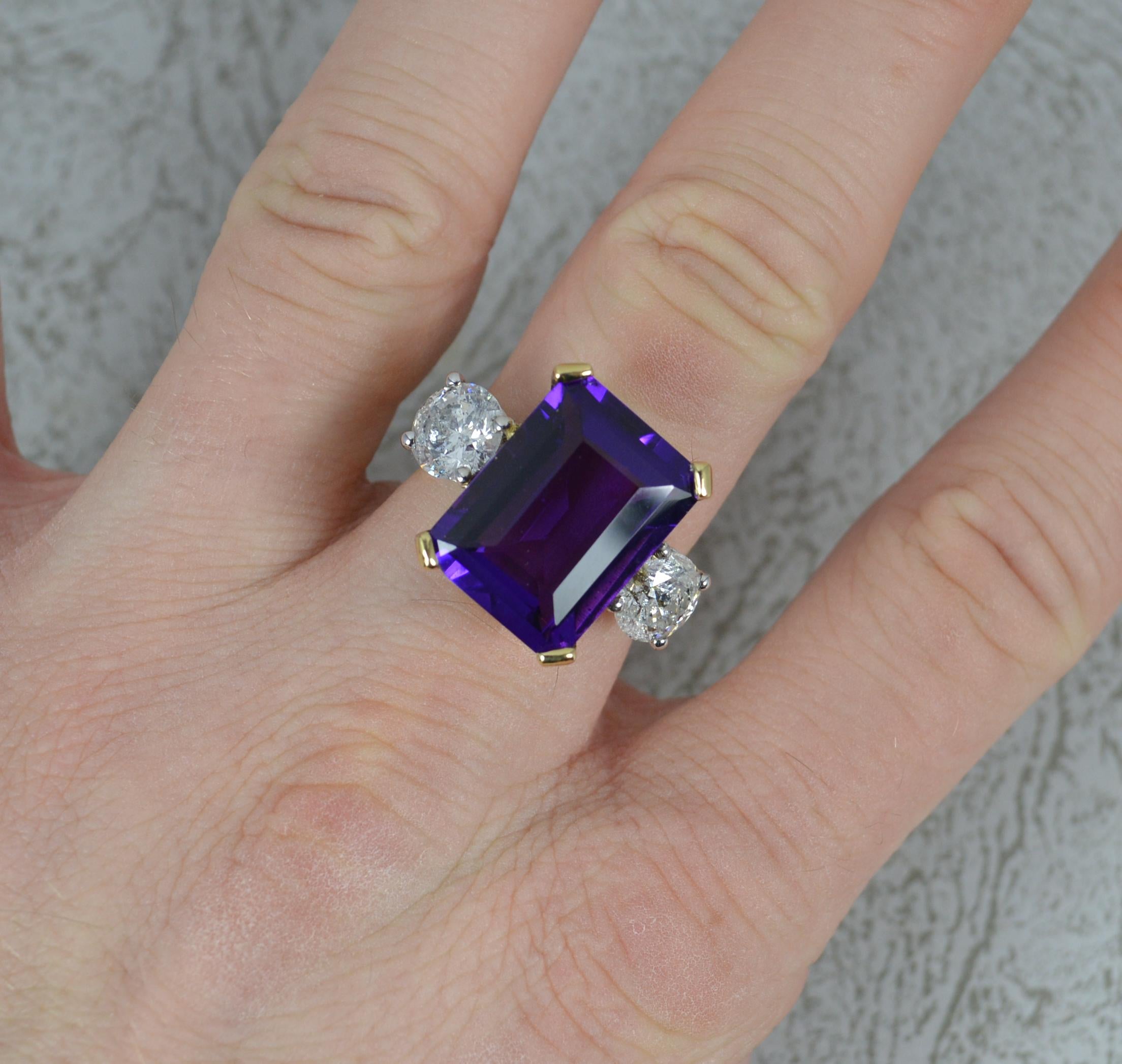 A stunning Amethyst and Diamond three stone ring.
Solid 18 carat yellow gold example with white gold settings for the diamonds.
Designed with a large emerald cut, vivid purple colour amethyst to centre in four claw setting. 12mm x 16mm stone.
To