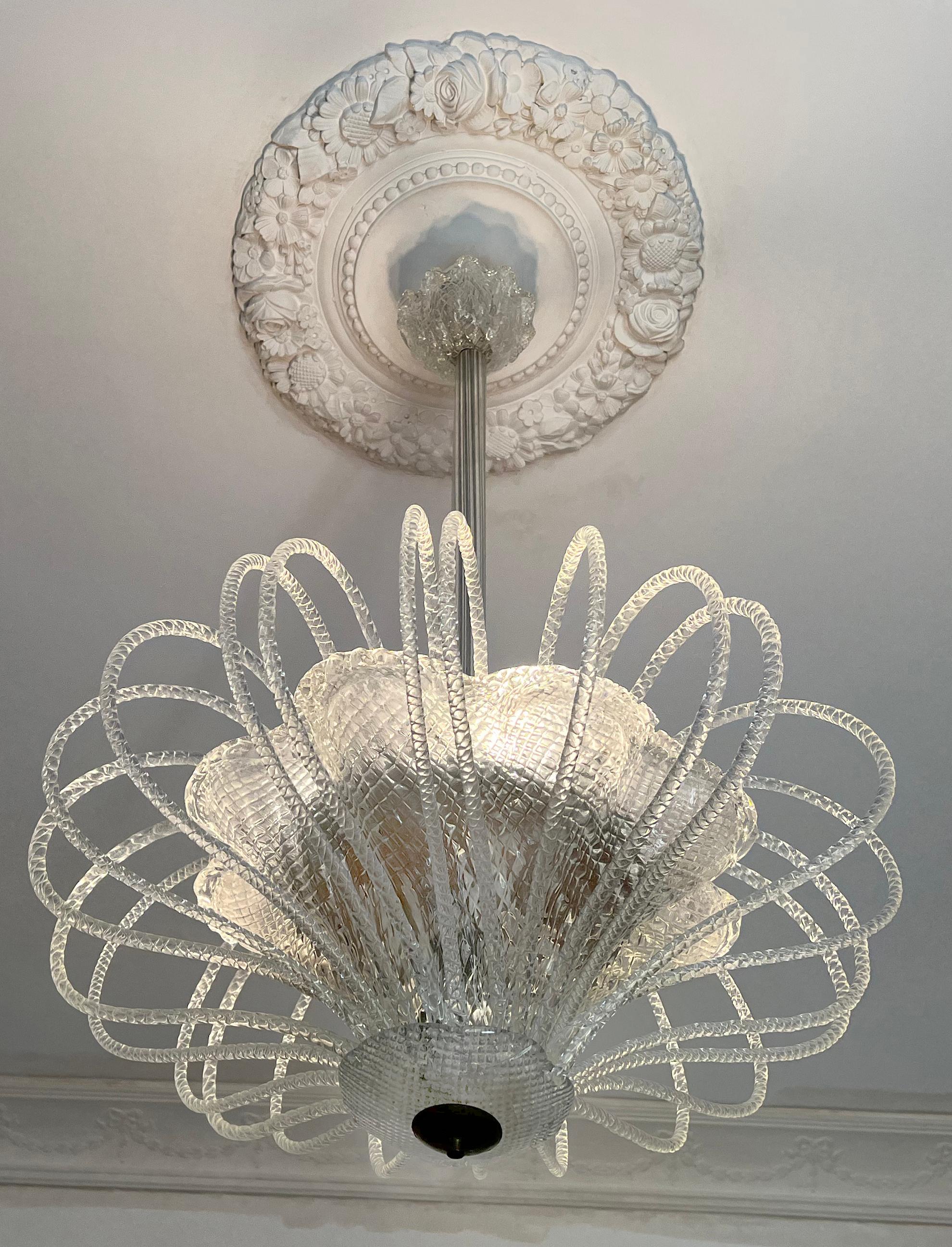 An extremely delicate and elegant chandelier by the famous Murano factory Barovier & Toso. Nearly two dozen glass spouts forming a stunning fountain of light. Placed the center of the room, a light sculpture gives the space a magical aura.

Light