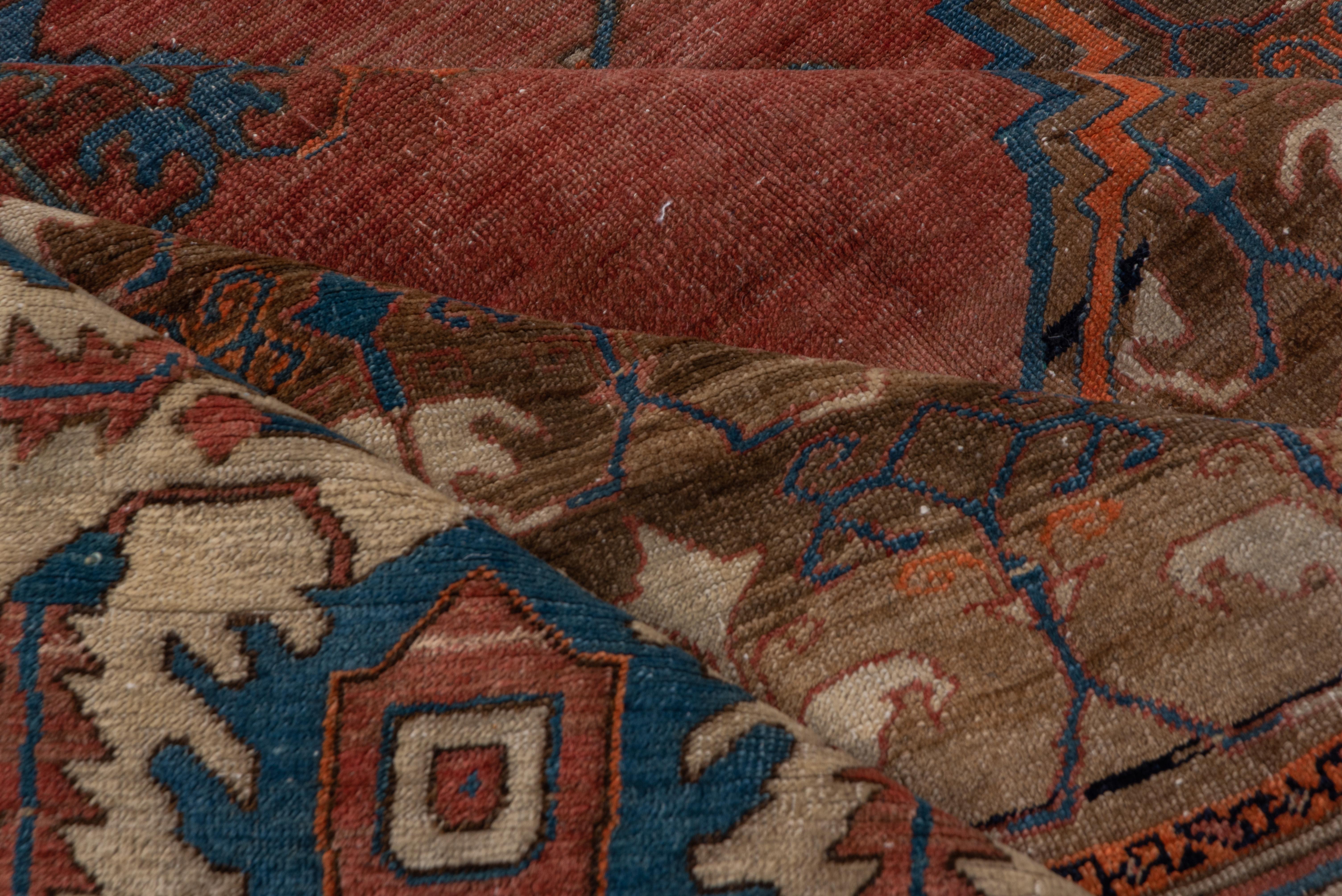 Bakhshayeh carpets are an older and more Primitive version of antique Serapi and heriz carpets. They circle back to the 1800s. The abrashed and stepped red subfield fits neatly into the primarily dark brown field with its unusual floral repeat