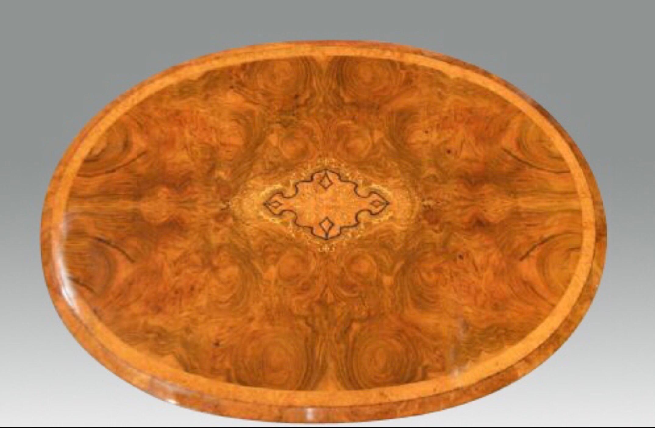 A beautiful burr walnut, amboyna and marquetry inlaid Victorian Period lamp table. The oval top veneered in beautifully figured burr walnut with a foliate marquetry inlaid central panel and cross banded in amboyna with a burr walnut moulded edge.