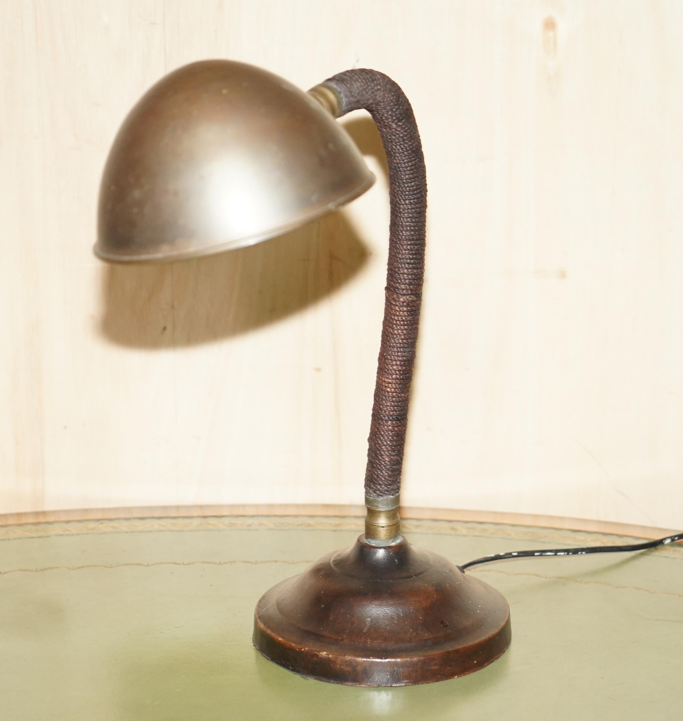 Nous sommes ravis d'offrir à la vente cette superbe lampe de banquier Art Deco circa 1930 en laiton avec finition bronzée, avec base en cuir cousue à la main et corps en corde tressée.

Une très belle pièce décorative, je n'en ai jamais vu de
