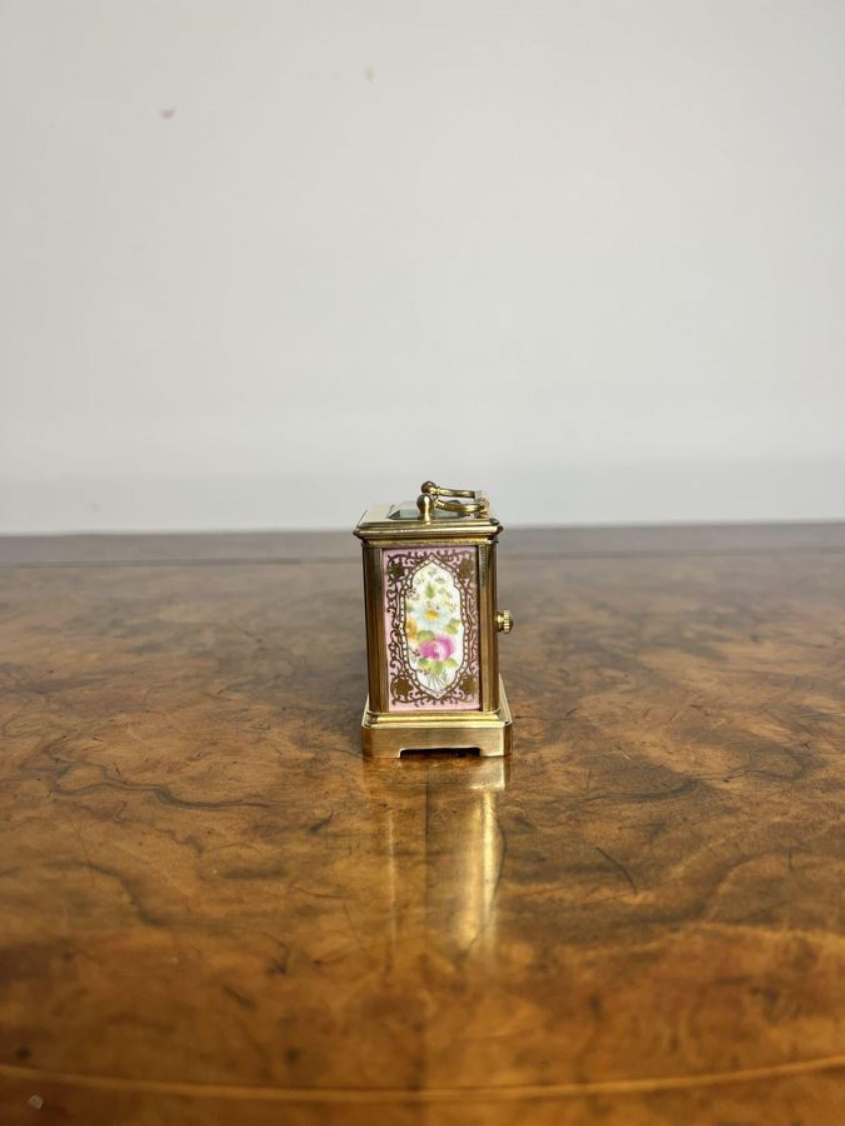 Magnifique horloge miniature en laiton de qualité édouardienne, avec de beaux panneaux en porcelaine peints à la main et décorés de fleurs roses, vertes et jaunes entourées de volutes dorées, avec un mouvement français de 8 jours, un cadran en