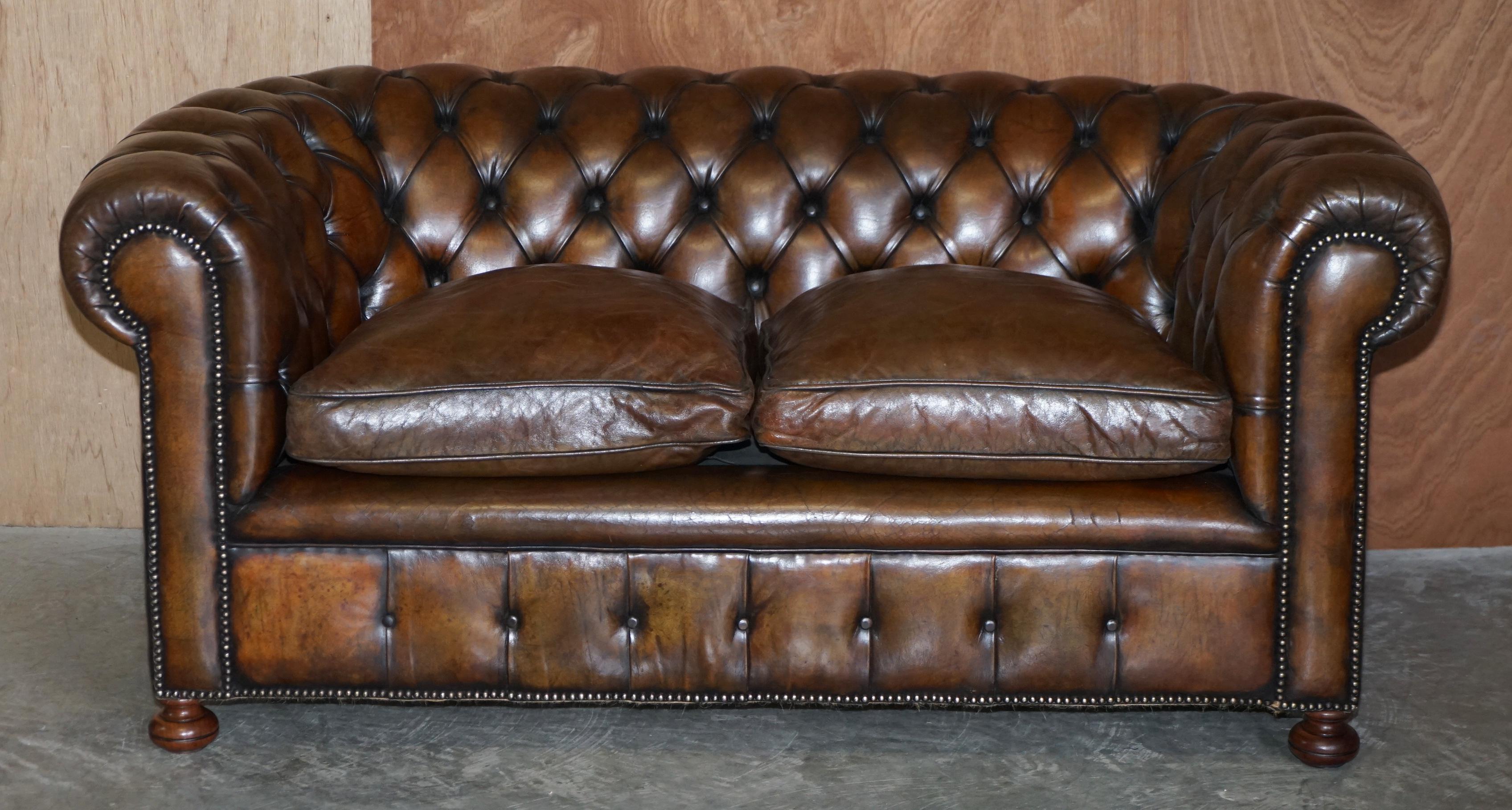 Nous sommes ravis d'offrir à la vente ce canapé club Chesterfield en cuir brun cigare, exceptionnellement rare et d'origine vers 1900, en état restauré, avec des coussins remplis de plumes et des pieds en chignon en noyer tournés à la main sur