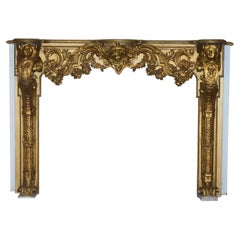 Superbe contour de cheminée Louis XV en bois doré ancien avec chérubin et motifs floraux sculptés