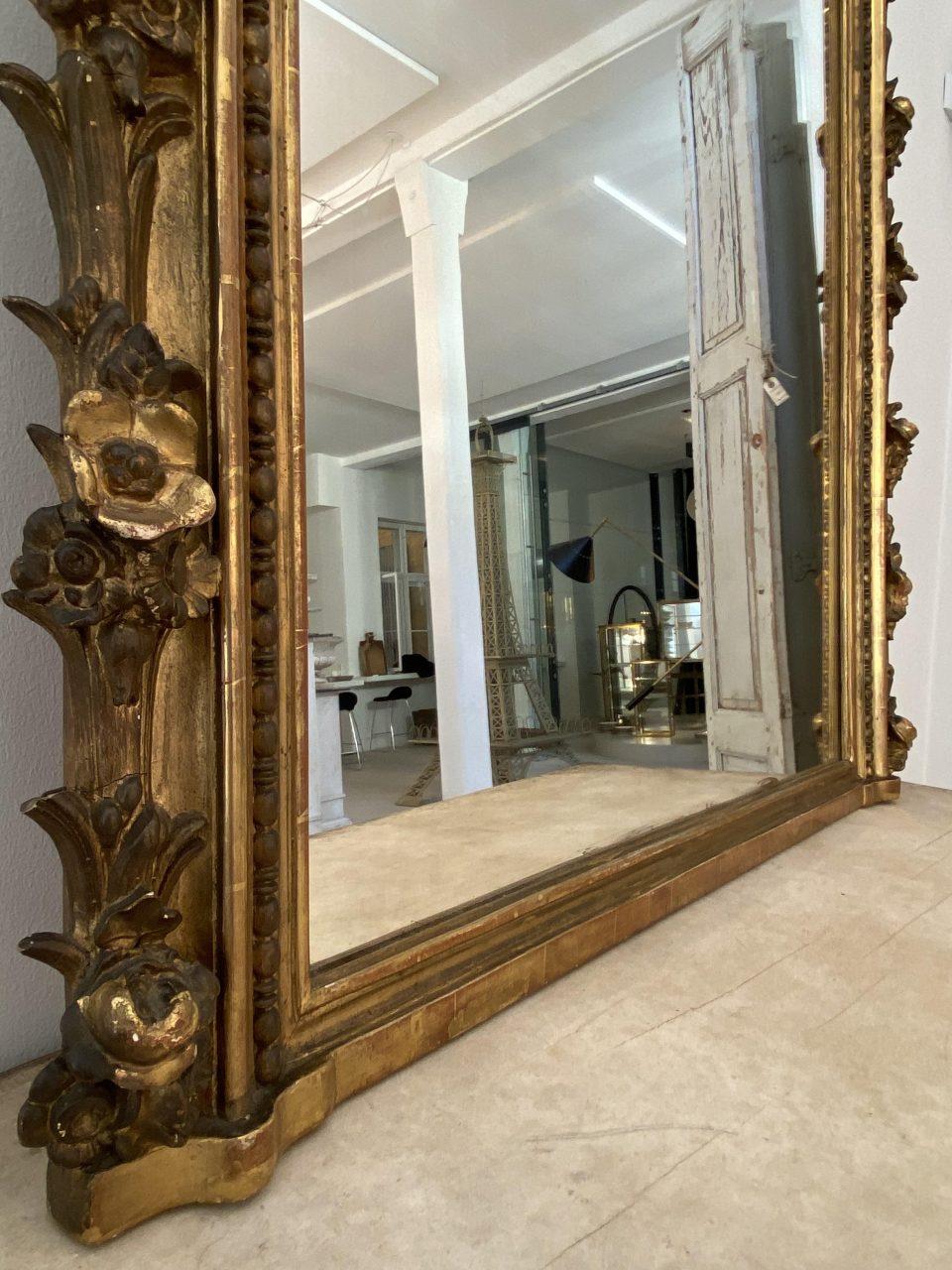 Stunning antique ornate golden mirror, circa 1870s France, typically seen hanging above a mantelpiece. Amazing details. Eye-catching. Original mercury mirror, surrounded by a beautiful and elegant wooden framed profile with rosettes and foliage and