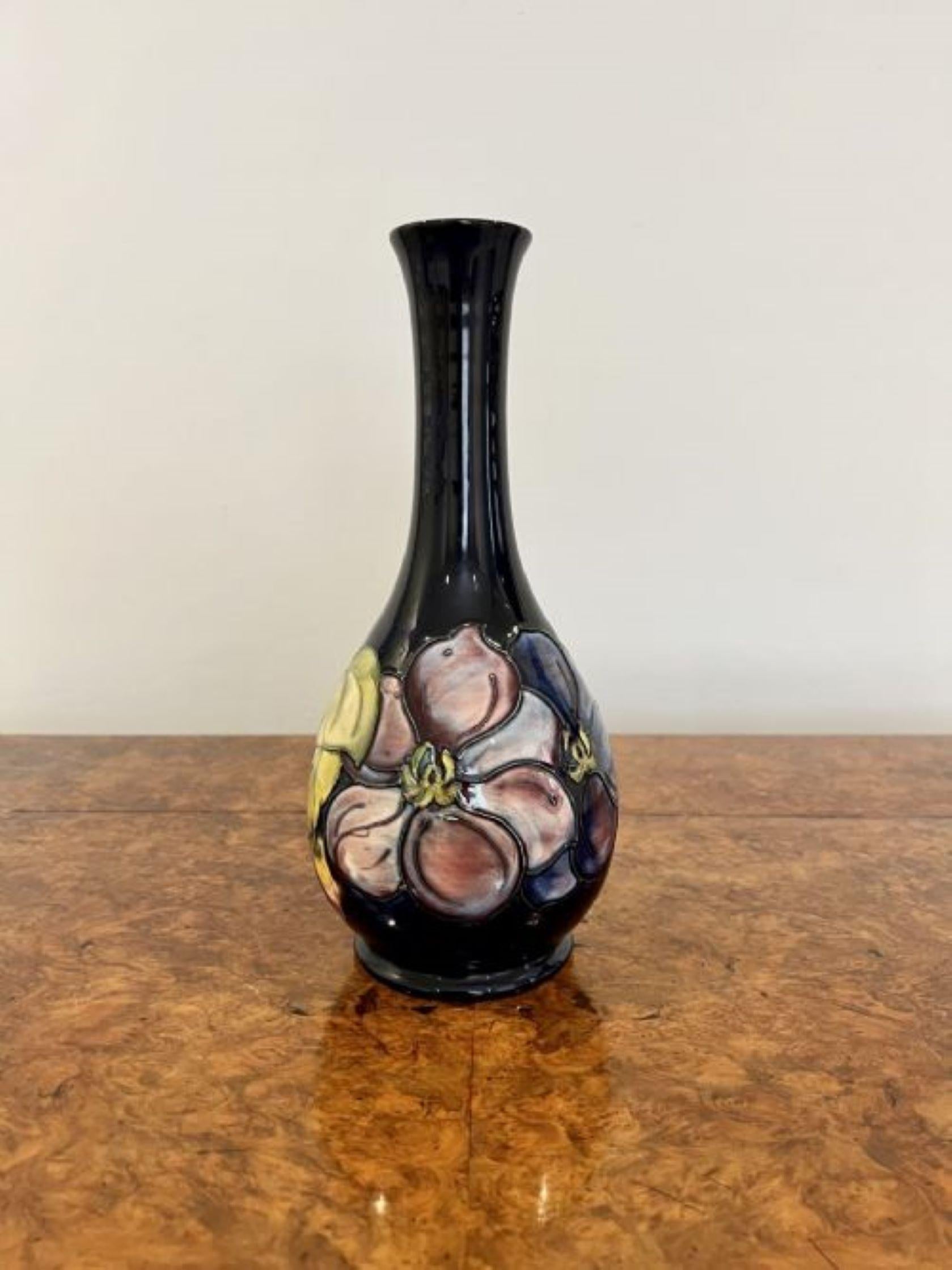 Stunning antique quality Moorcroft vase having a quality antique Moorcroft vase decorated with flowers in wonderful pink, yellow and blue colours on a navy blue background. Signature to the base as shown. 