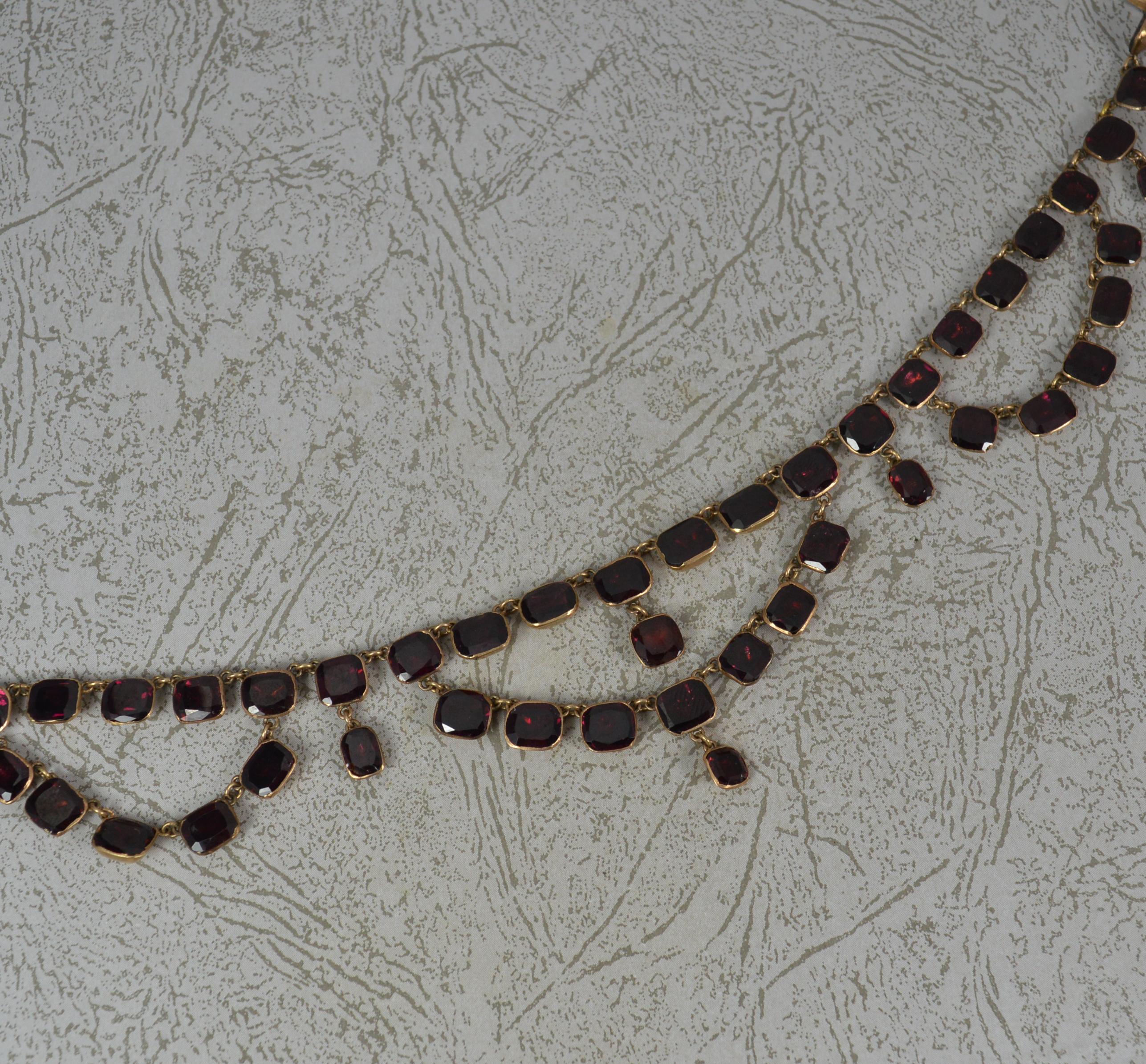 A fine quality riviere necklace.
Solid 15 carat rose gold example.
Superb example, circa 1820-1840. 
Set with 66 natural cushion shaped garnets, set into foiled, closed back settings. A triple drop dangle design.


CONDITION ; Excellent for age.