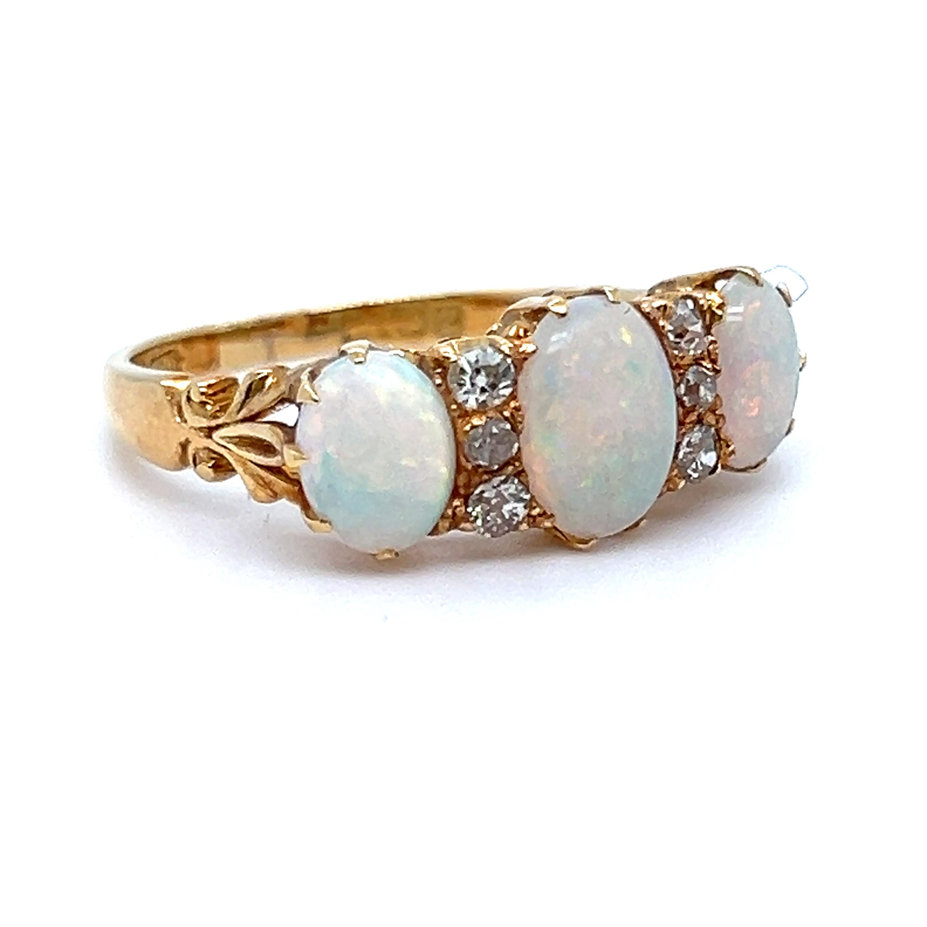 Opals bring such a unique quality to any piece, and the opals on this Stunning Antique Victorian Opal Wedding Band are lively and full of fire! The design features wonderful classic three stone layout with diamonds spacers, lovely scroll work, and