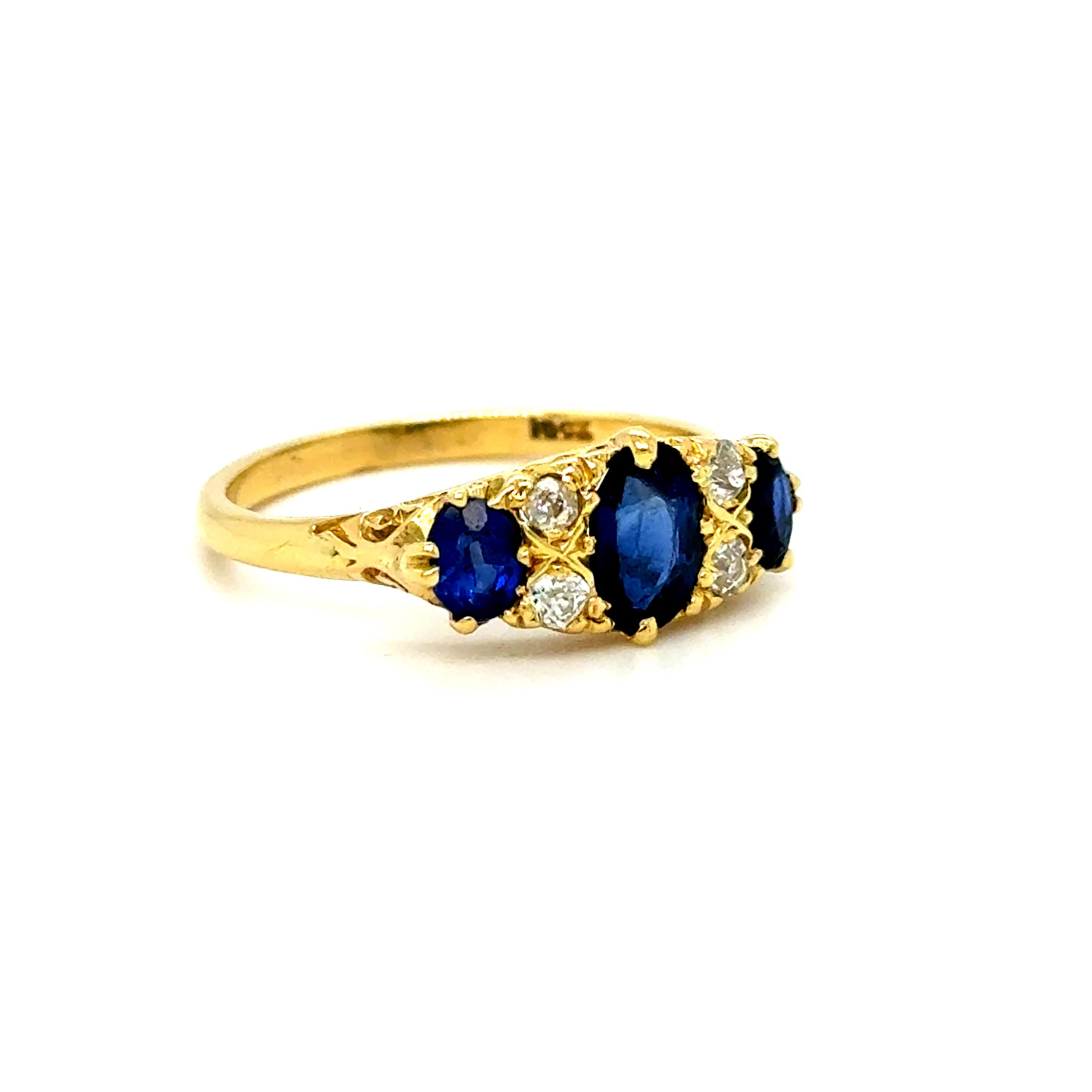Cette superbe alliance ancienne en saphir et diamant est magnifique ! Le design présente une merveilleuse disposition classique de trois pierres avec des diamants intercalaires et un ravissant travail de parchemin visible de profil ! Il y a au total