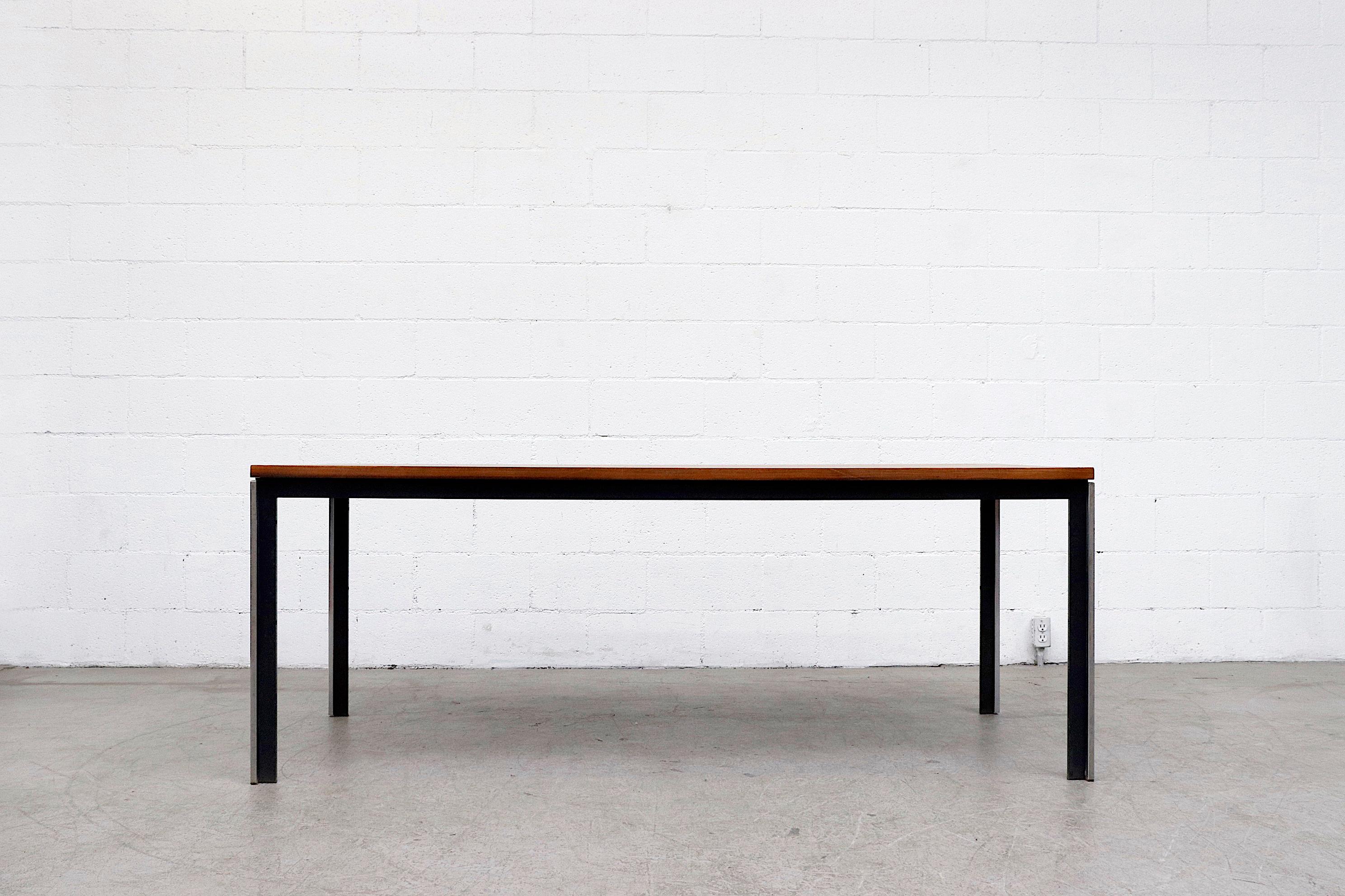 Intriguing architecturally designed Polak dining or conference table with lightly refinished teak top, black enameled metal and polished steel industrial frame. Innovative configuration of metal and polished steel. In original condition with some