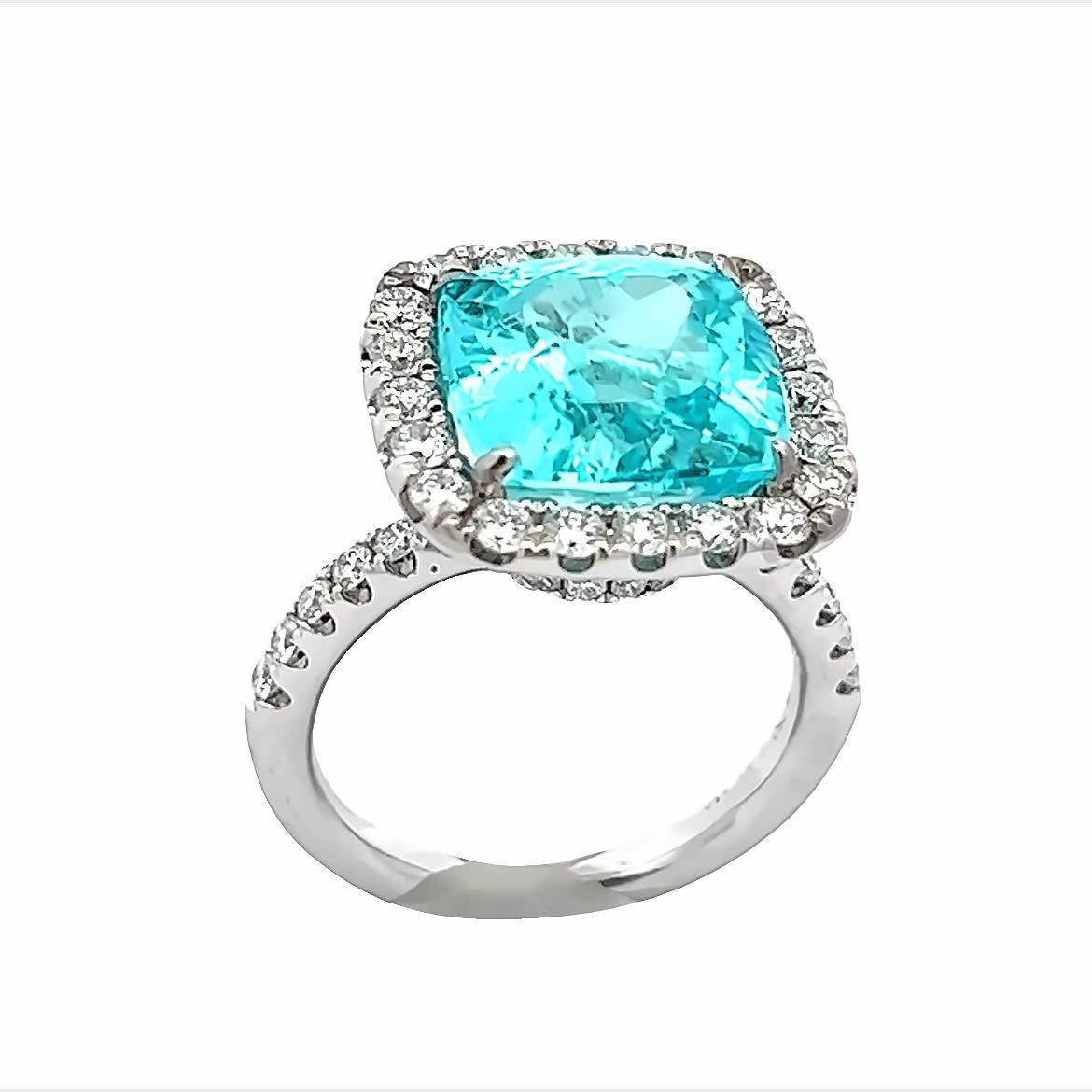 Dieser exquisite Ring besticht durch einen aquablauen Edelstein, der von einem Halo aus funkelnden Diamanten umgeben ist. Das filigrane Design und die leuchtende Farbe machen sie zu einem perfekten Accessoire für jede Gelegenheit. Werten Sie Ihre