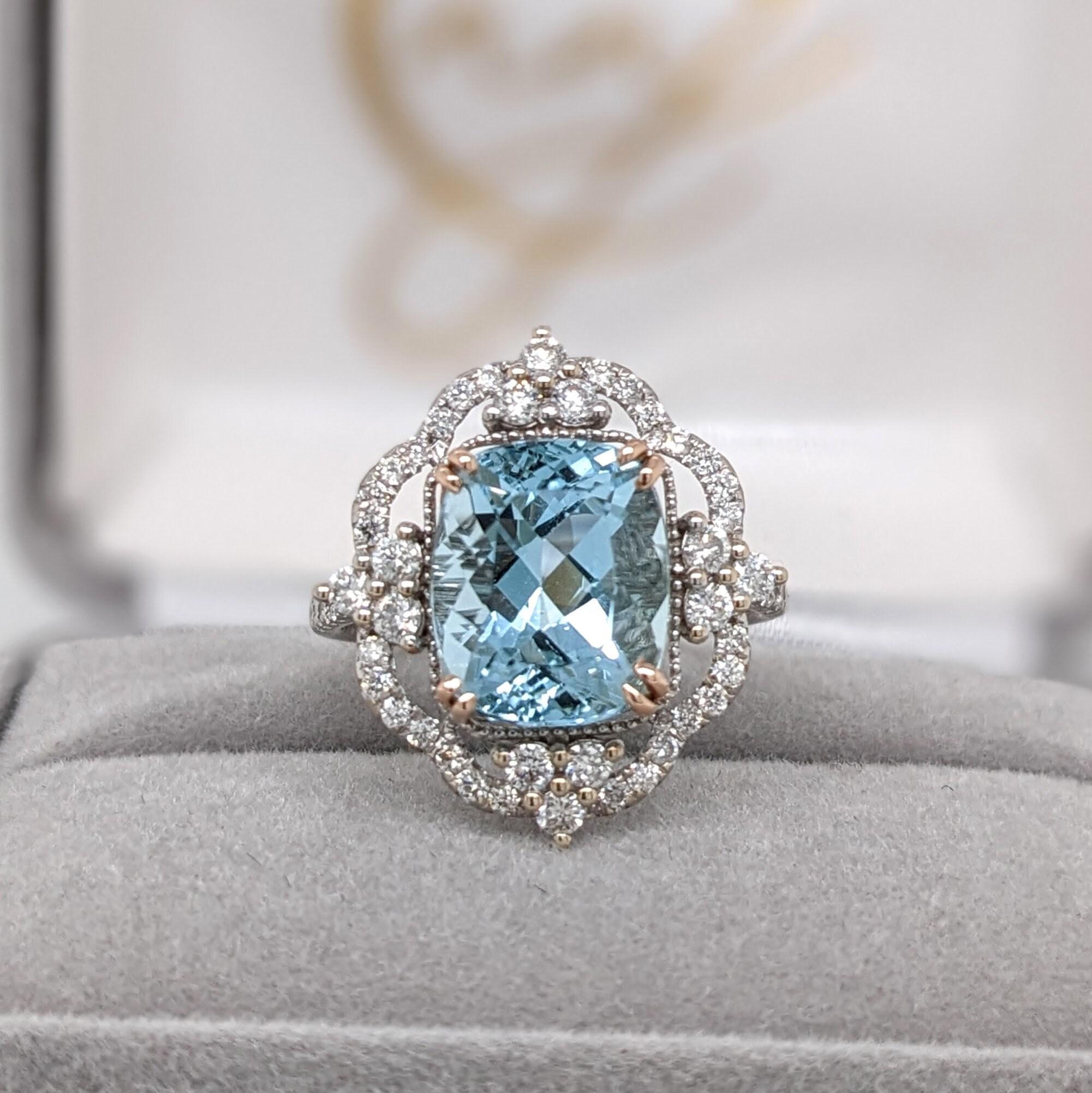 This beautiful ring features a cushion cut sparkling Aquamarine in 14k dual tone rose and white gold with a gorgeous design of halo  round natural diamond accents. A statement ring design perfect for an eye catching engagement or anniversary. This