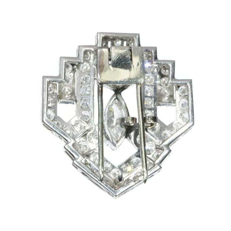 Centring a marquise cut diamond and fully encrusted with 65 single brilliant cut diamonds, this platinum Art Deco brooch from 1930 could be your woman's medal of honour. The strong openwork lozenge design with a terraced top and the repeated