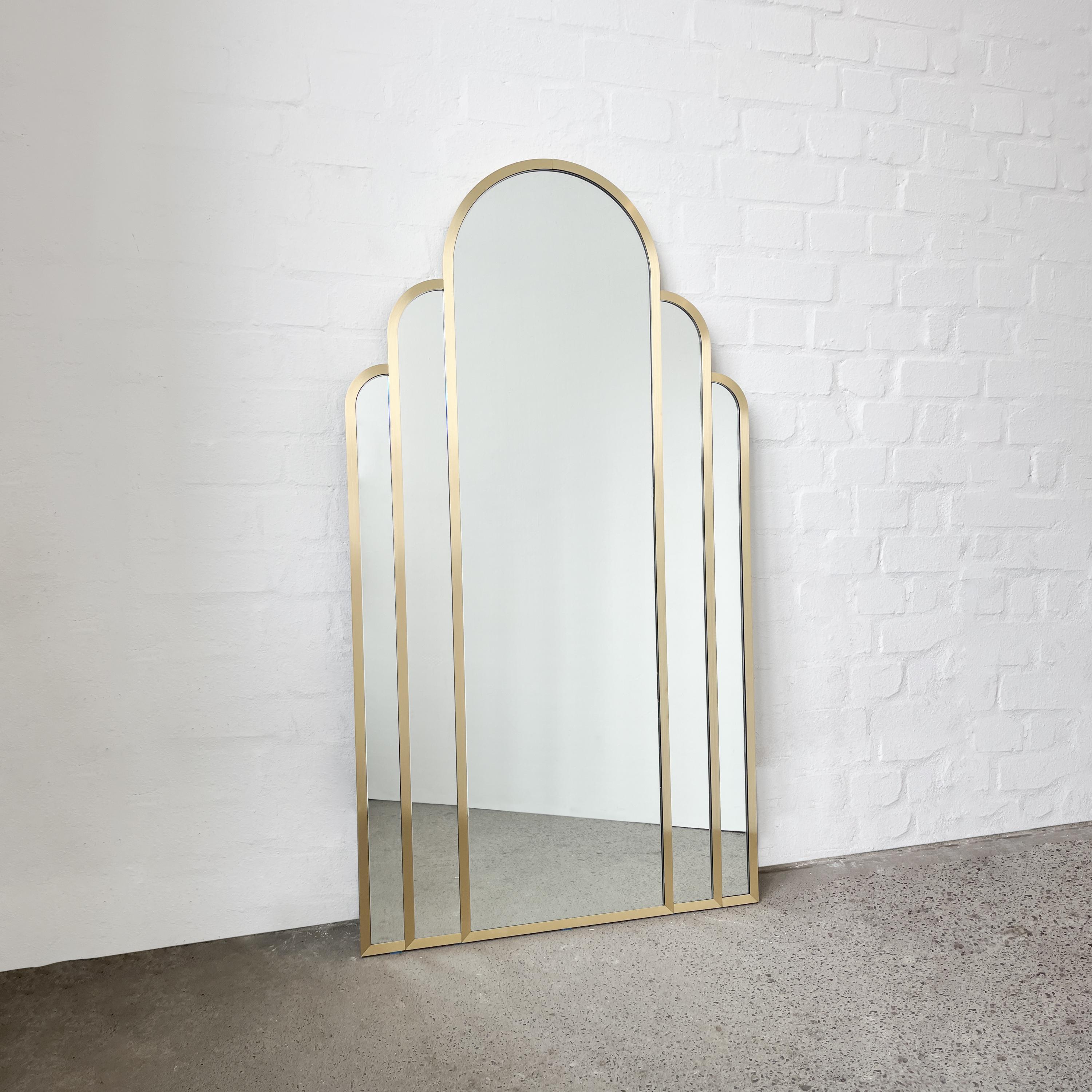 Exquis miroir arqué d'inspiration Art déco avec un solide cadre en laiton brossé. Cette pièce étonnante est composée de cinq arcs élégants et d'un cadre complet finement brossé et sans soudure. Fabriqué à la main à Londres, au Royaume-Uni, selon des
