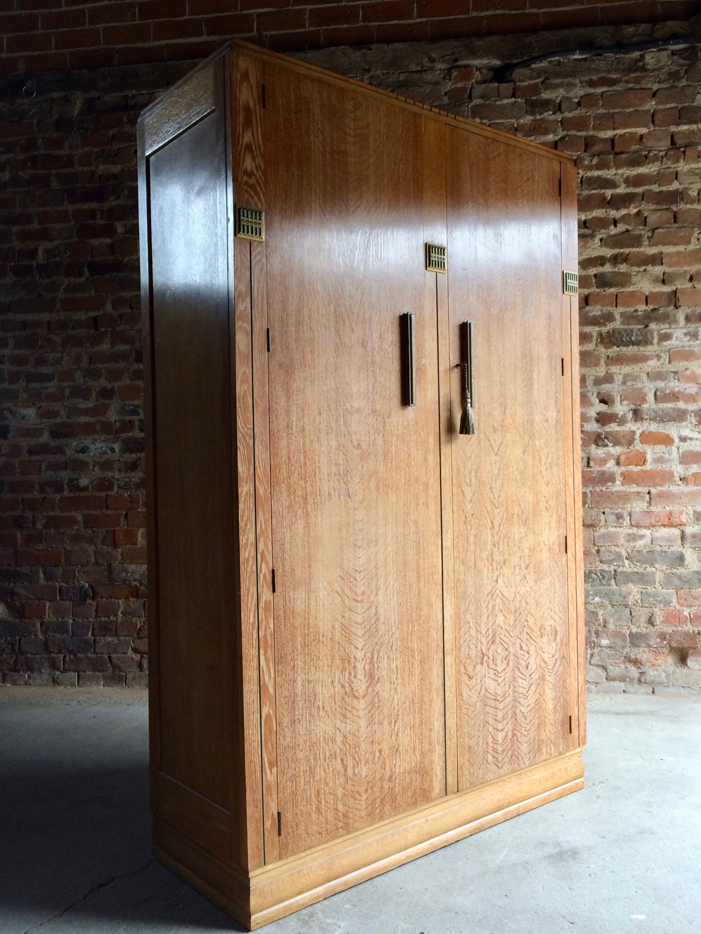 In the manner of Heals a fabulous Limed Oak wardrobe, circa 1930, with highlighting green and gold painted sections, comes with one working key with tassel.

Condition: The piece is offered in excellent condition with no odours, the doors open and