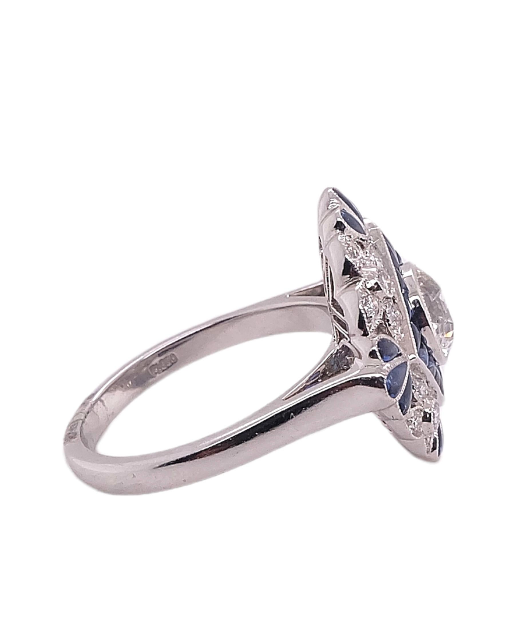 Ring im Art-Déco-Stil, gefasst in Platin. Der Ring besteht aus einem rund geschliffenen zentralen Diamanten mit einem Gewicht von 0,93 Karat, ergänzt durch blaue Saphire mit einem Gewicht von 0,95 Karat und kleine Diamanten mit einem Gewicht von