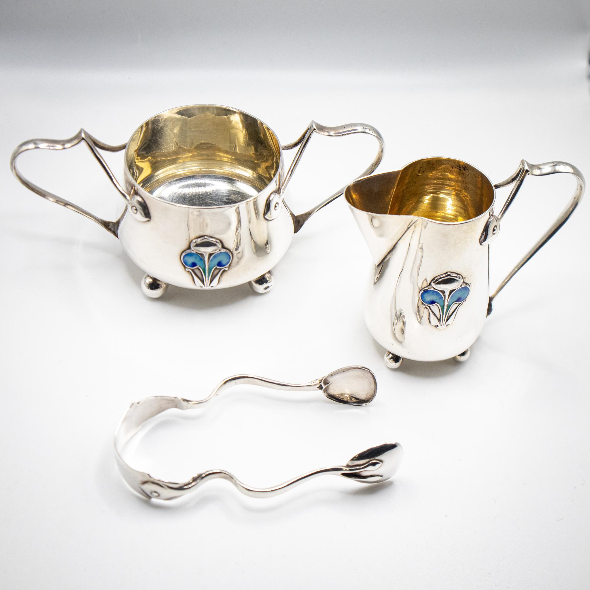 Stunning Art Nouveau Silver Bachelor Trio. This exquisite and diminutive Art Nouveau silver bachelor trio, crafted by James Fenton in Birmingham, 1906, epitomizes elegance and craftsmanship of the era. Adorned with delicate blue enamel floral